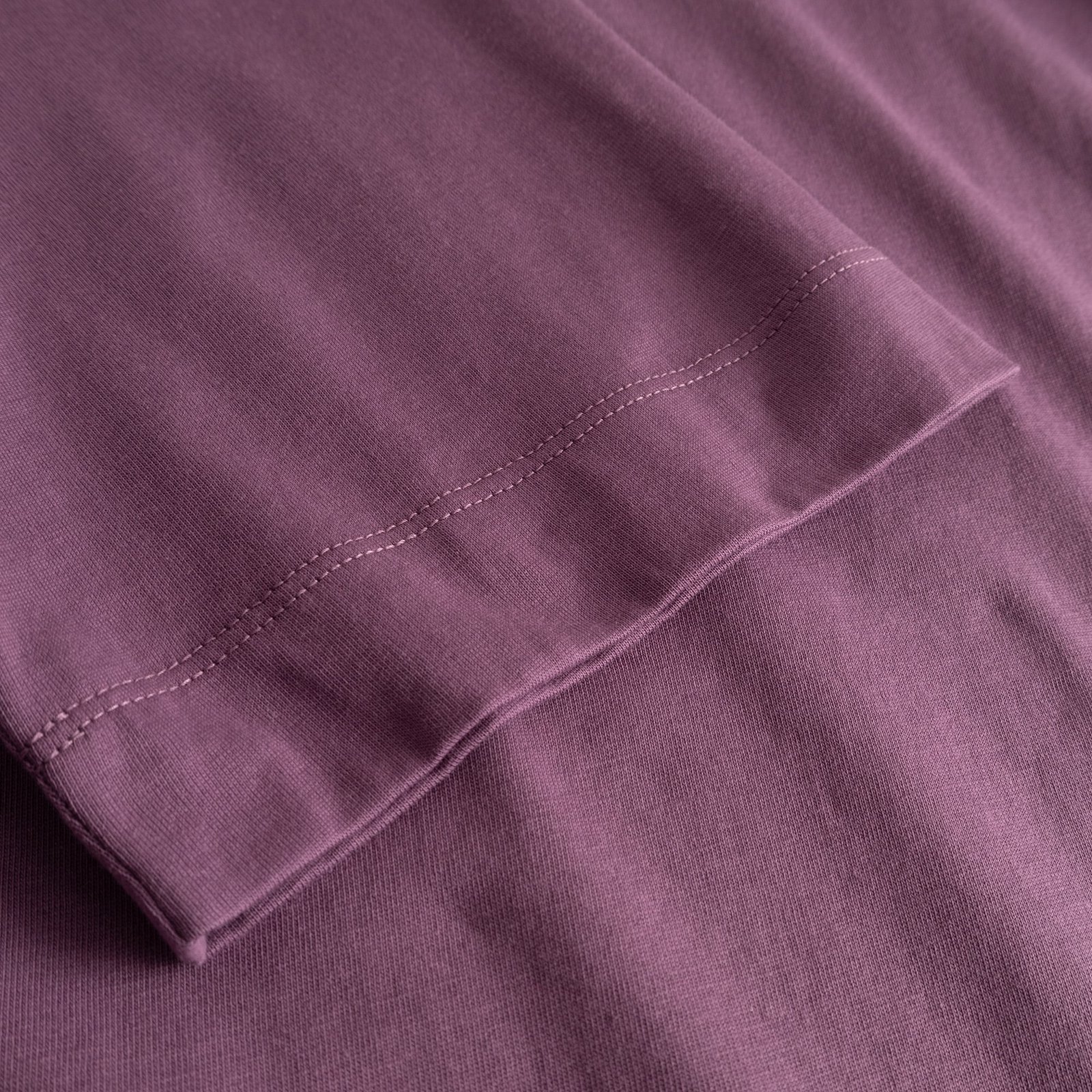 Close-up of the T-shirt Vadstena Base in Berry Purple, showing the soft fabric and stitching on the sleeve.