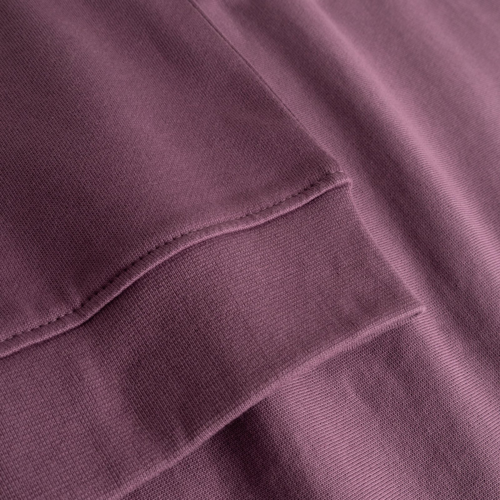 A close-up of the finely ribbed cuff and sleeve of the Ystad Base sweatshirt in a lovely Berry Purple.