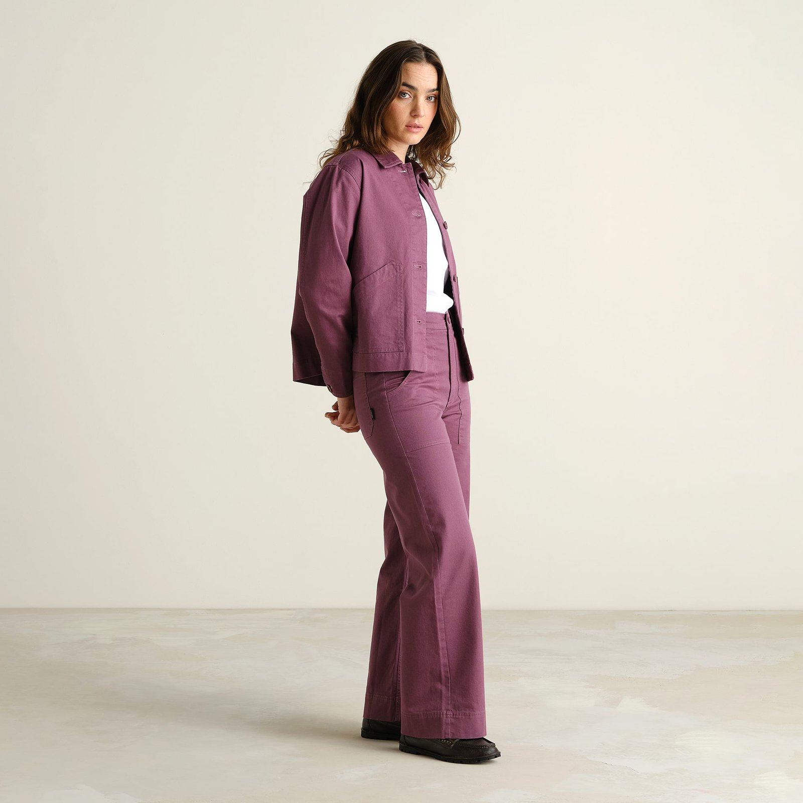 Sidovy av kvinna som bär högmidjade Workwear Pants Vara i Berry Purple och en matchande jacka.
