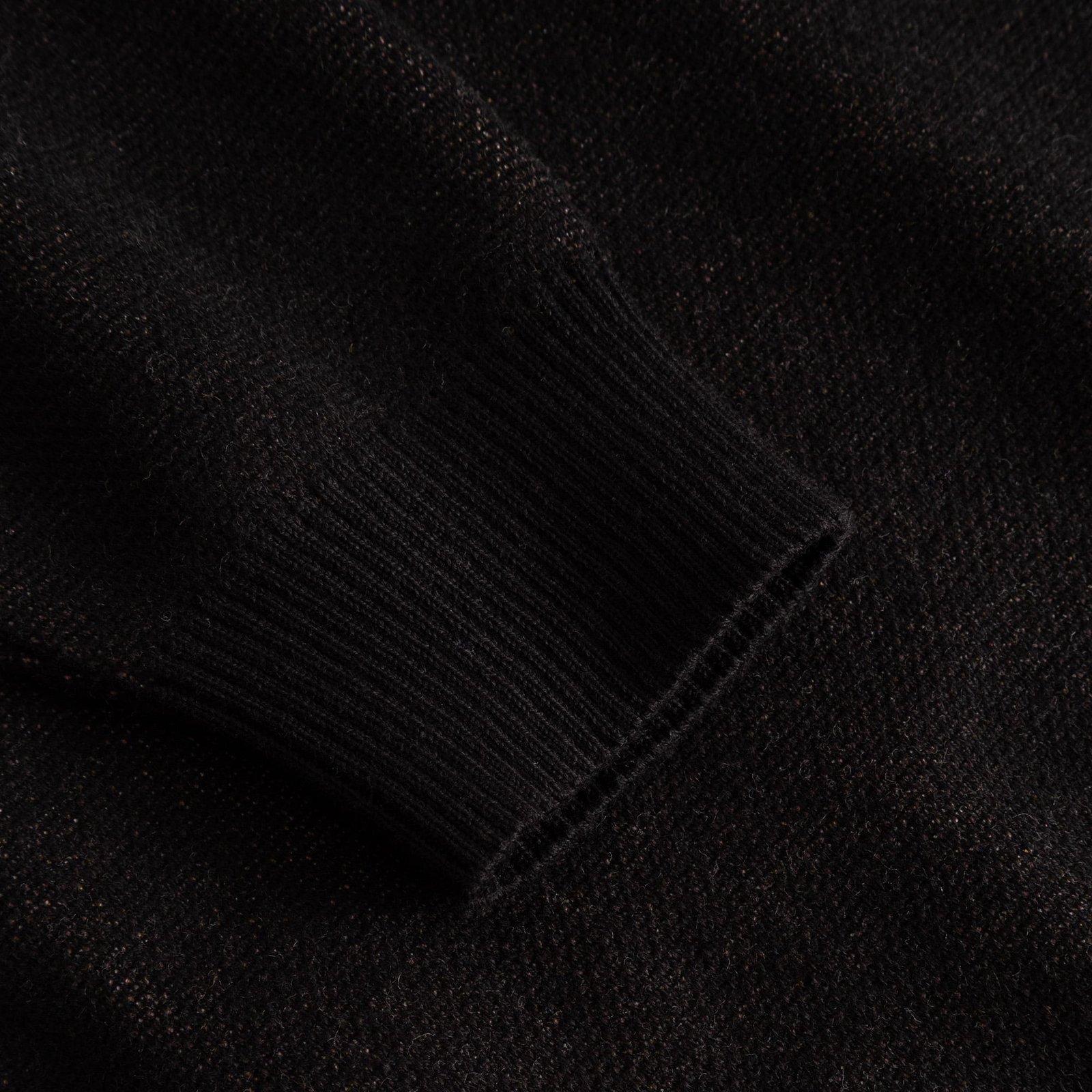 A detailed close-up of the ribbed sleeve cuff on the black Sweater Arendal Long Cat.