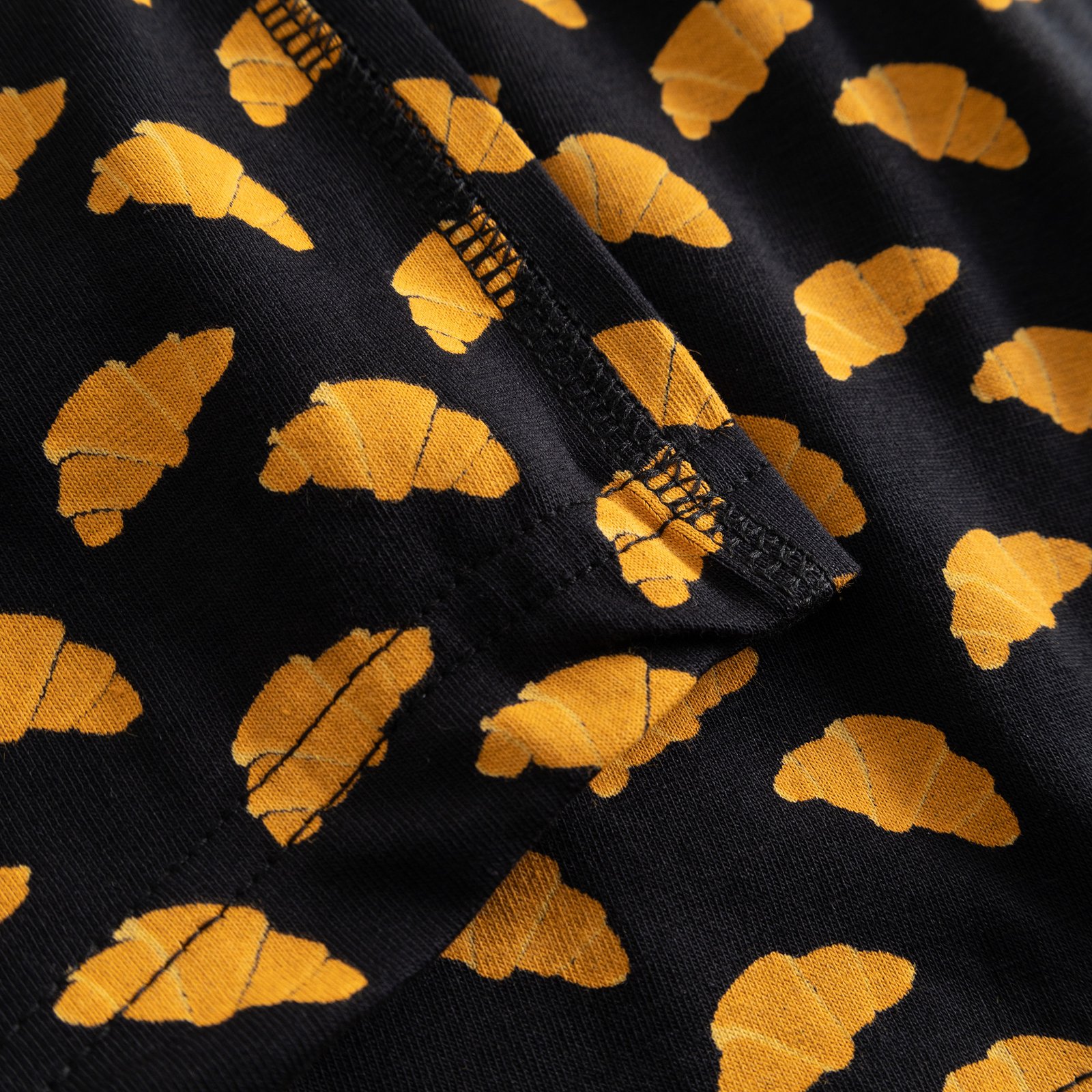 Close-up shot of the Dedicated Kalix Boxer Briefs in black, highlighting the fun all-over croissant print and fabric details.