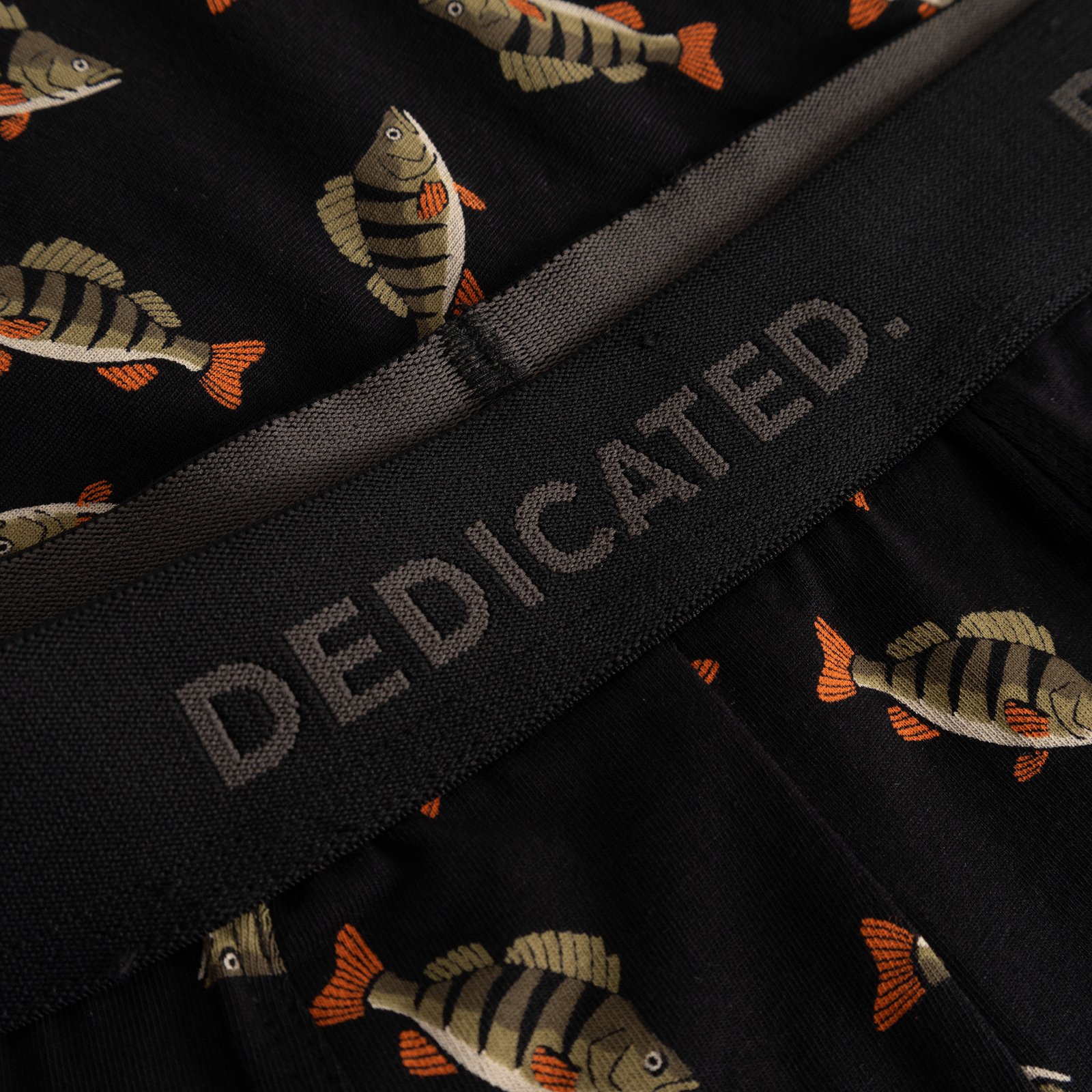 A close-up shot of the Kalix Boxer Briefs in black, showing the perch fish print and the Dedicated logo on the waistband.
