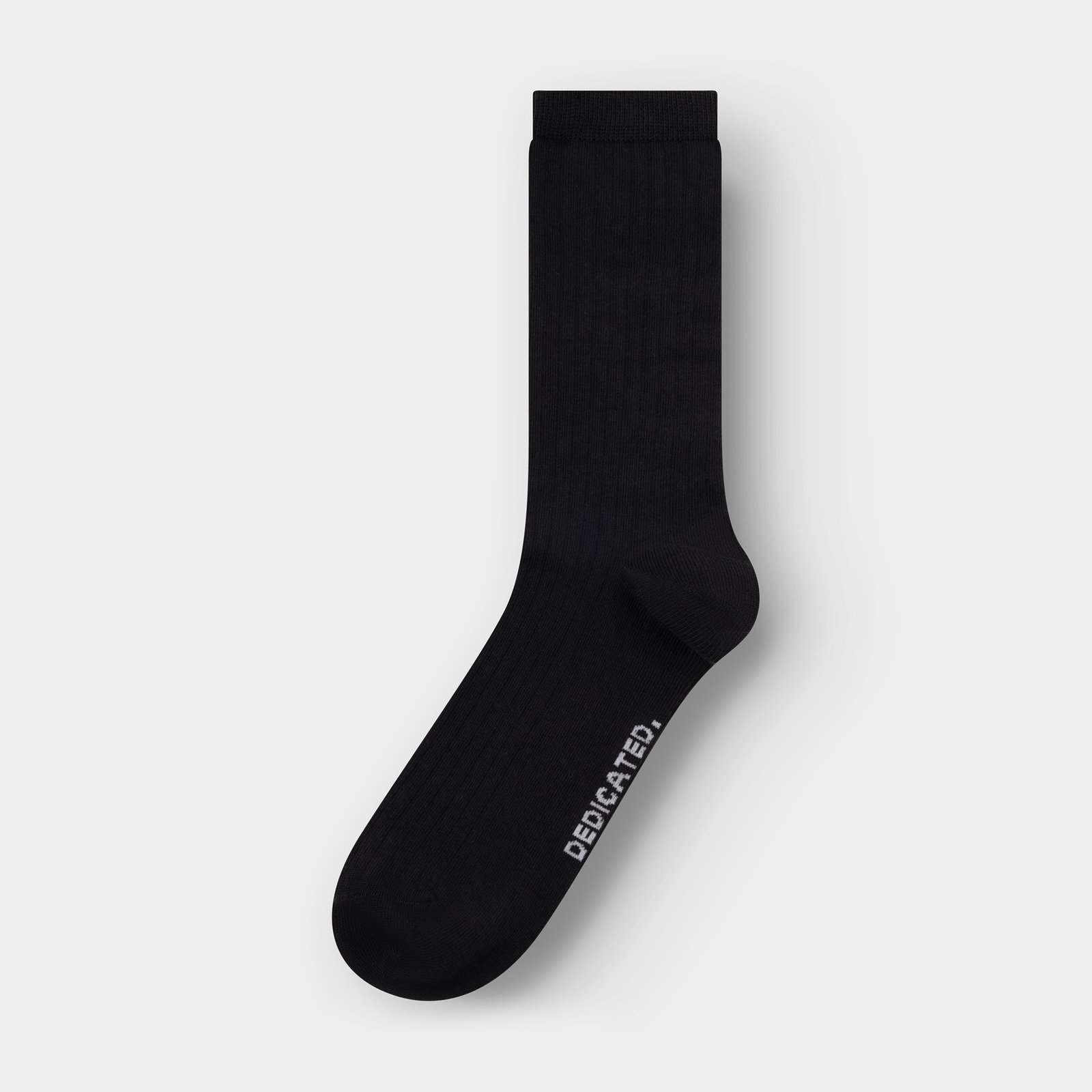 A single black ribbed sock, the Knivsta style, is laid flat on a light grey background.