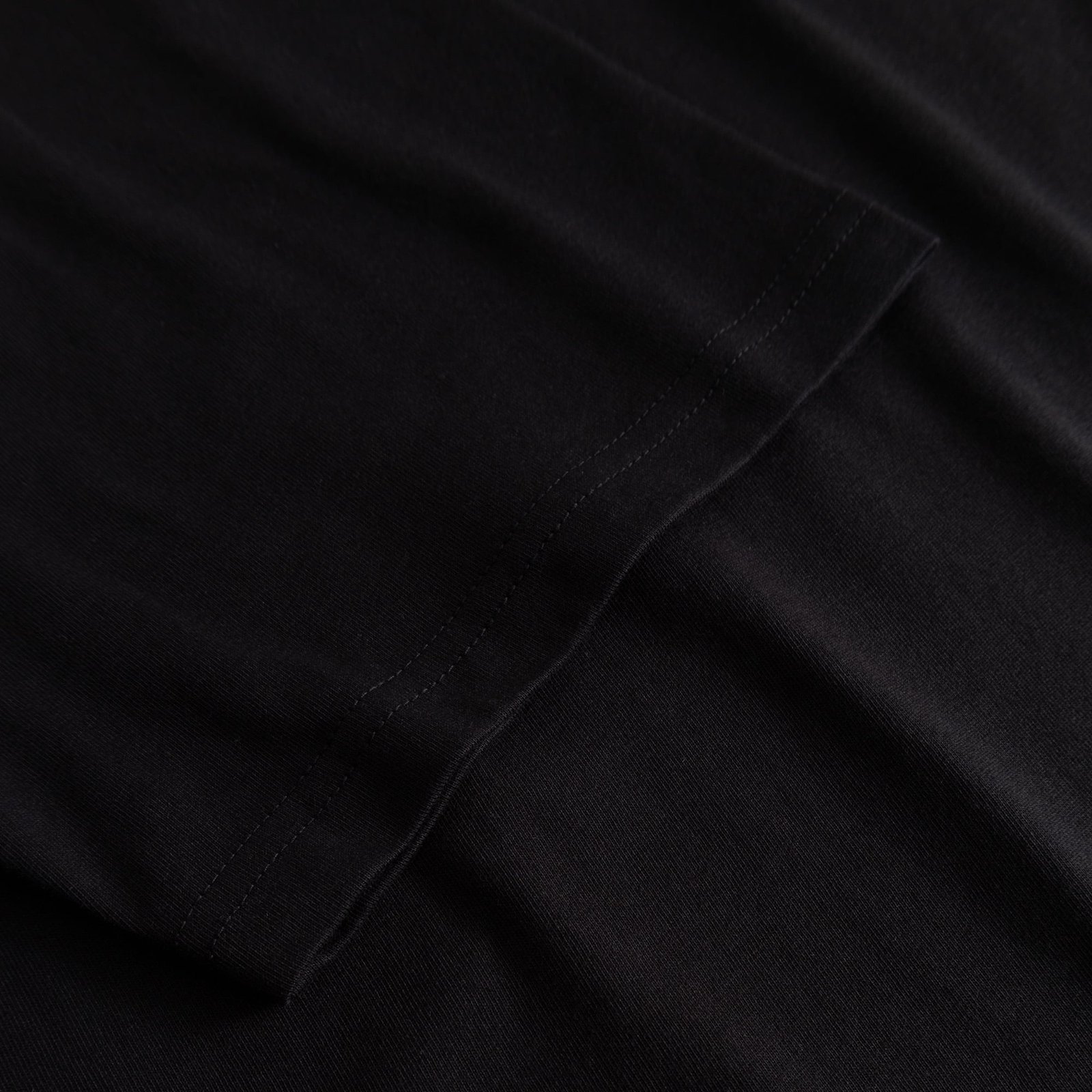 Close-up of the finely stitched sleeve on the T-shirt Stockholm My Imaginary Friends in black.