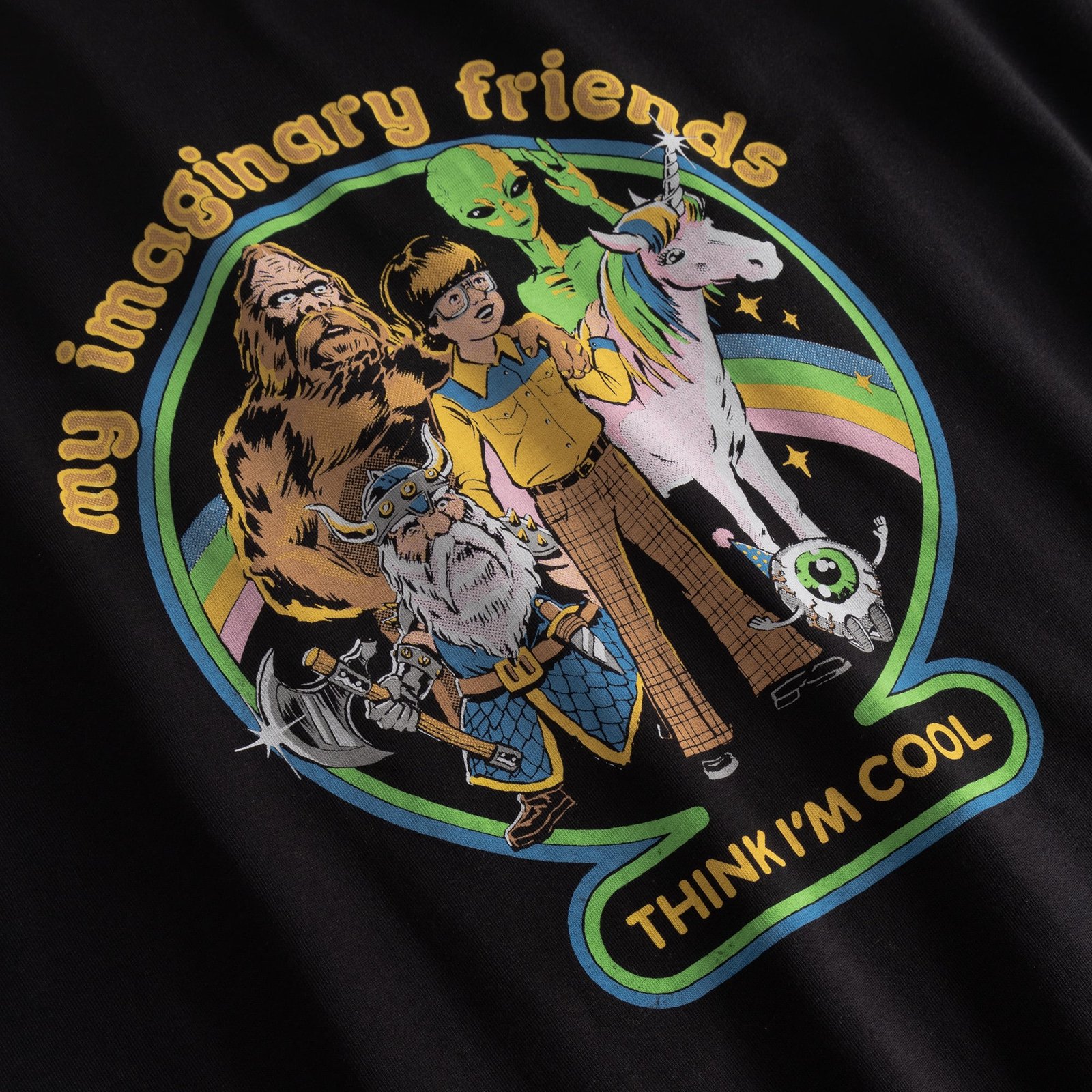Close-up on the retro-style 'My Imaginary Friends' print on a black t-shirt, featuring a boy, a sasquatch, and an alien.