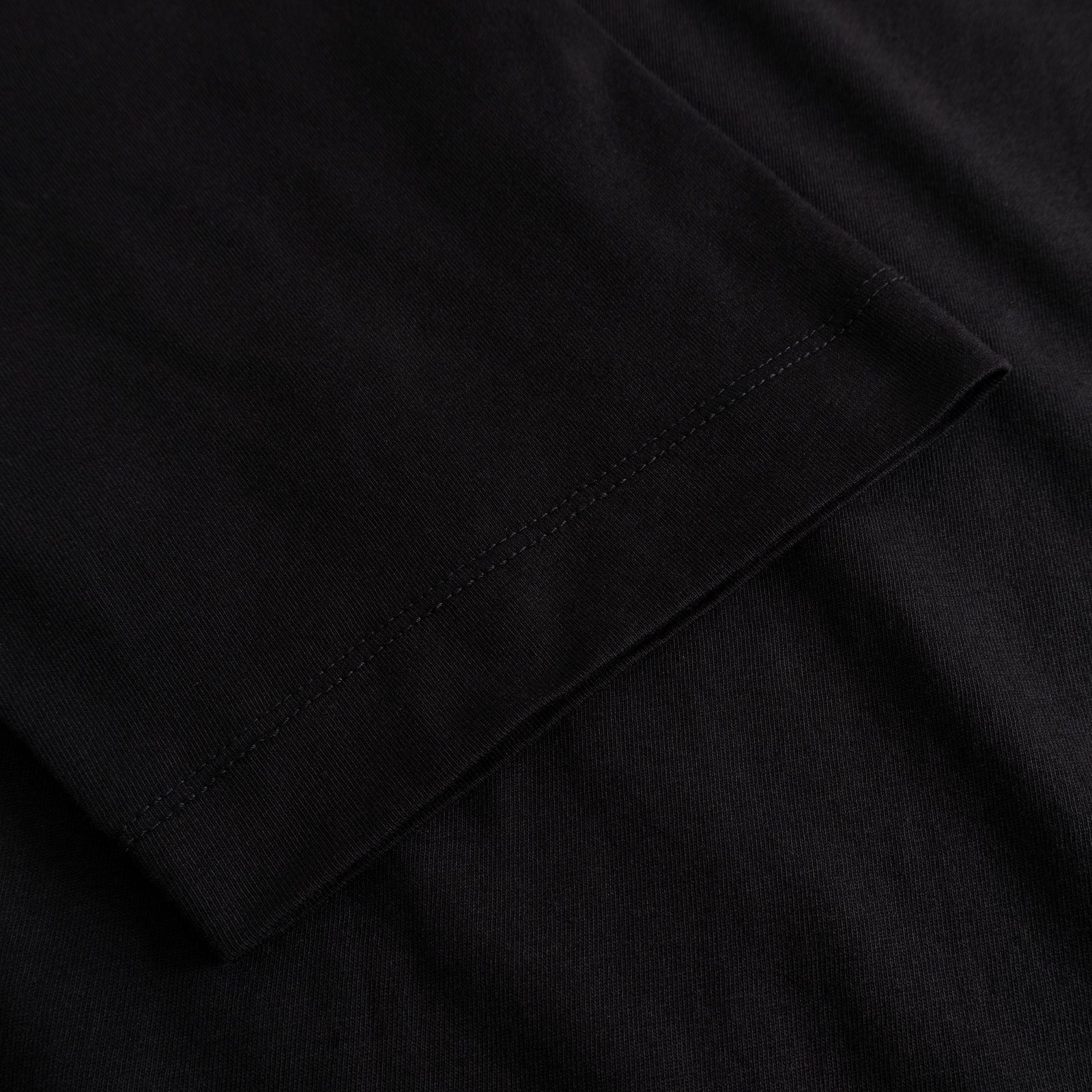 Close-up of the sleeve detail on the T-shirt Vadstena Hanging With All My Friends, showing the soft black organic cotton.