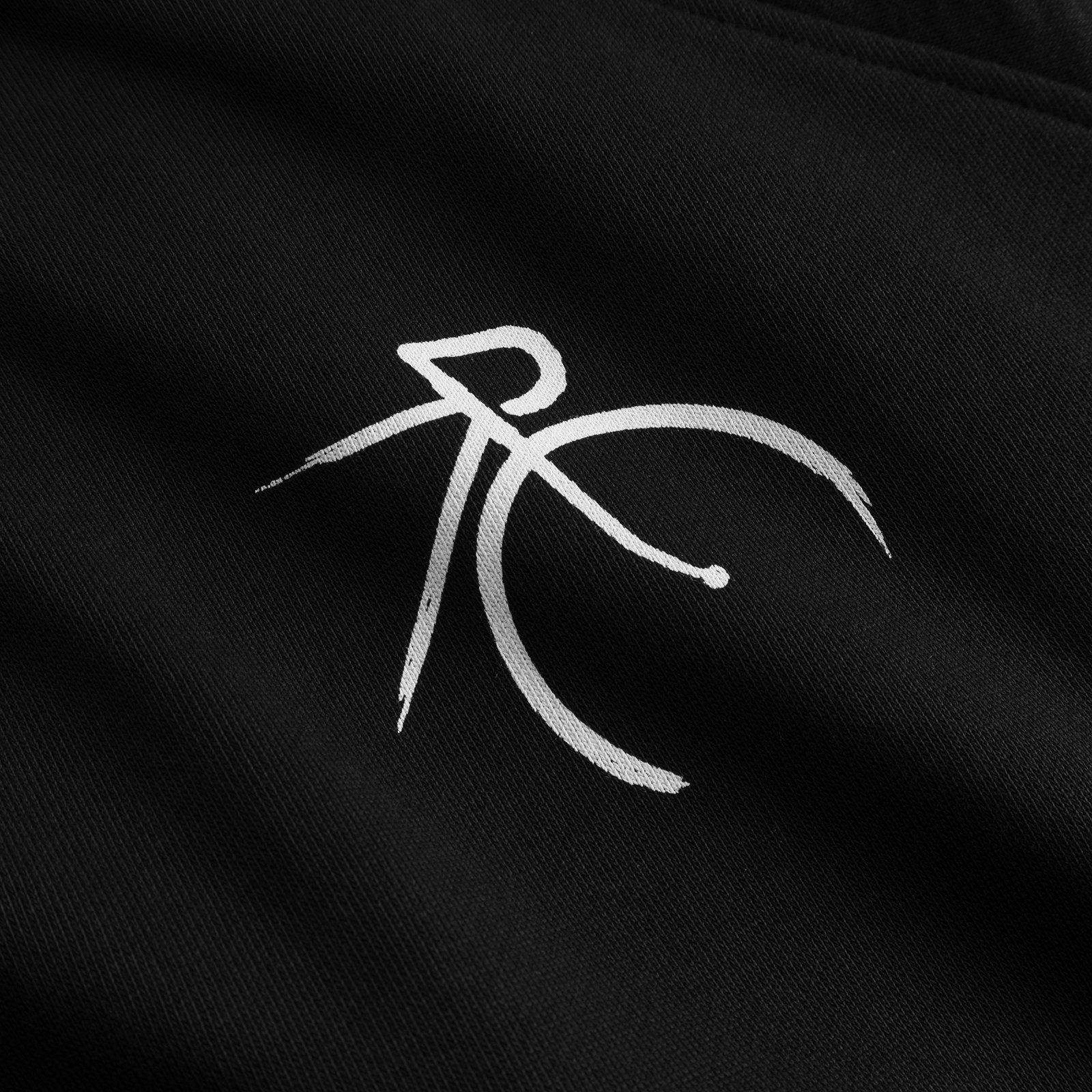 A close-up of the white, brushstroke-style 'Painted Side Bike' graphic on the black organic cotton sweatshirt.