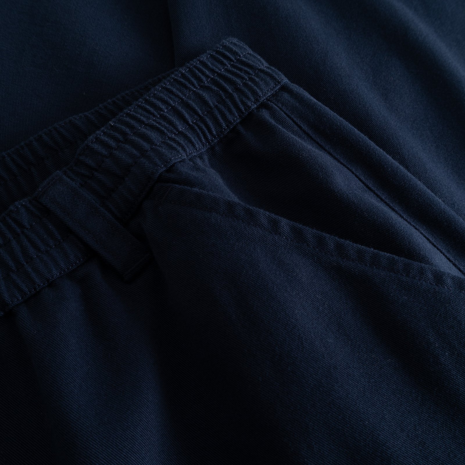 Close-up detail of the Hudiksvall Chino Pants in navy, highlighting the elastic waistband and organic cotton twill.