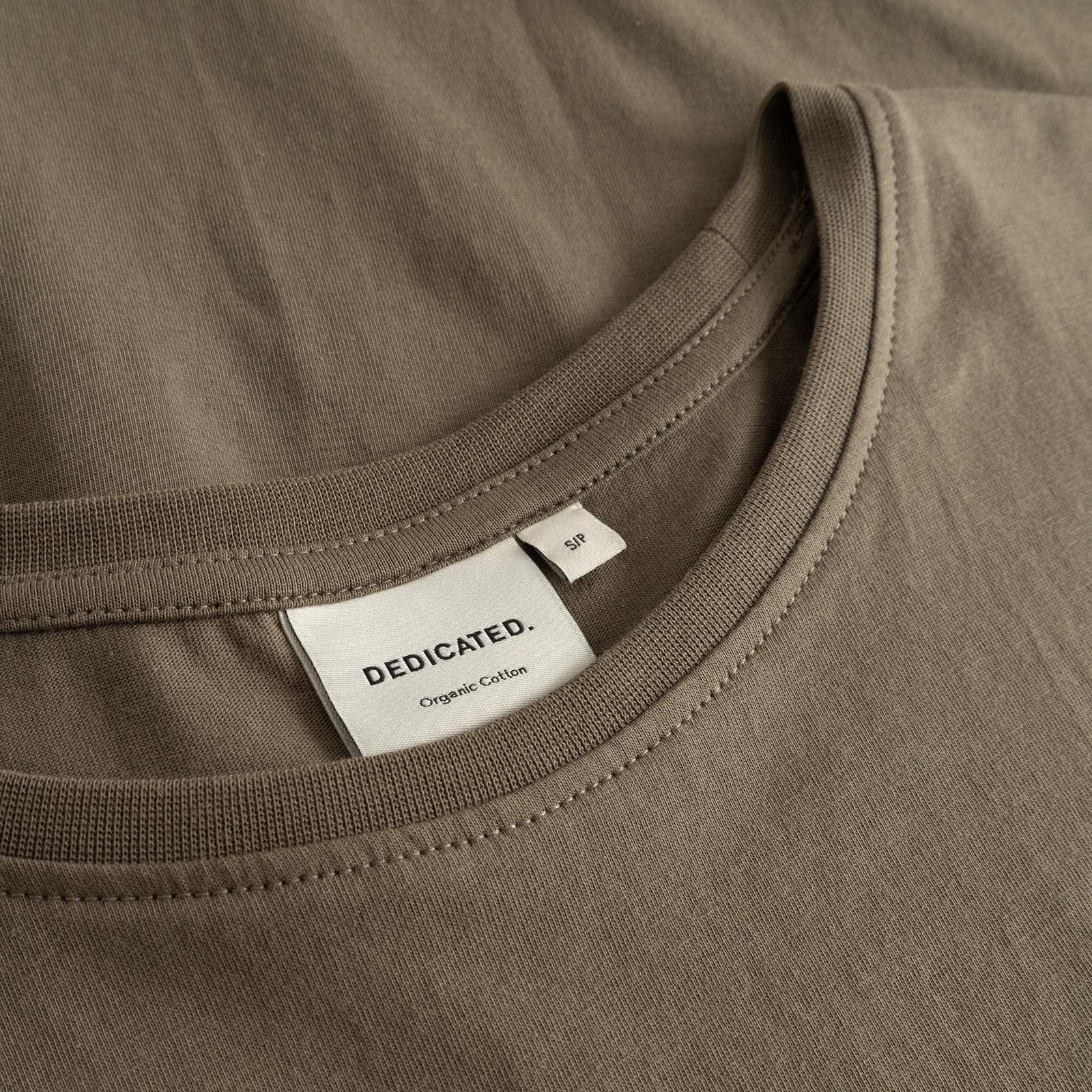 Detailed close-up of the ribbed neckline and brand label of the Dedicated T-shirt Visby Base Bungee Green.