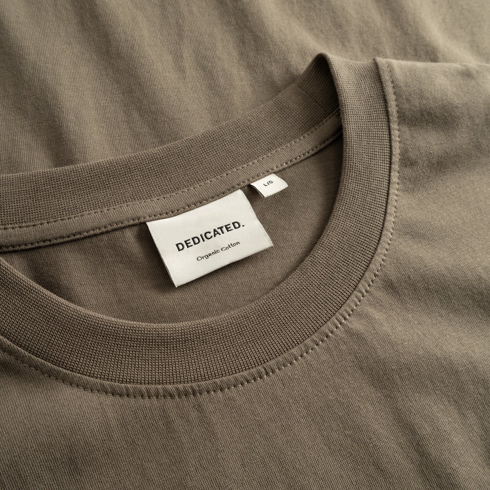 Närbild på den ribbade halsringningen och nacketiketten på T-shirt Stockholm Base i Bungee Green.