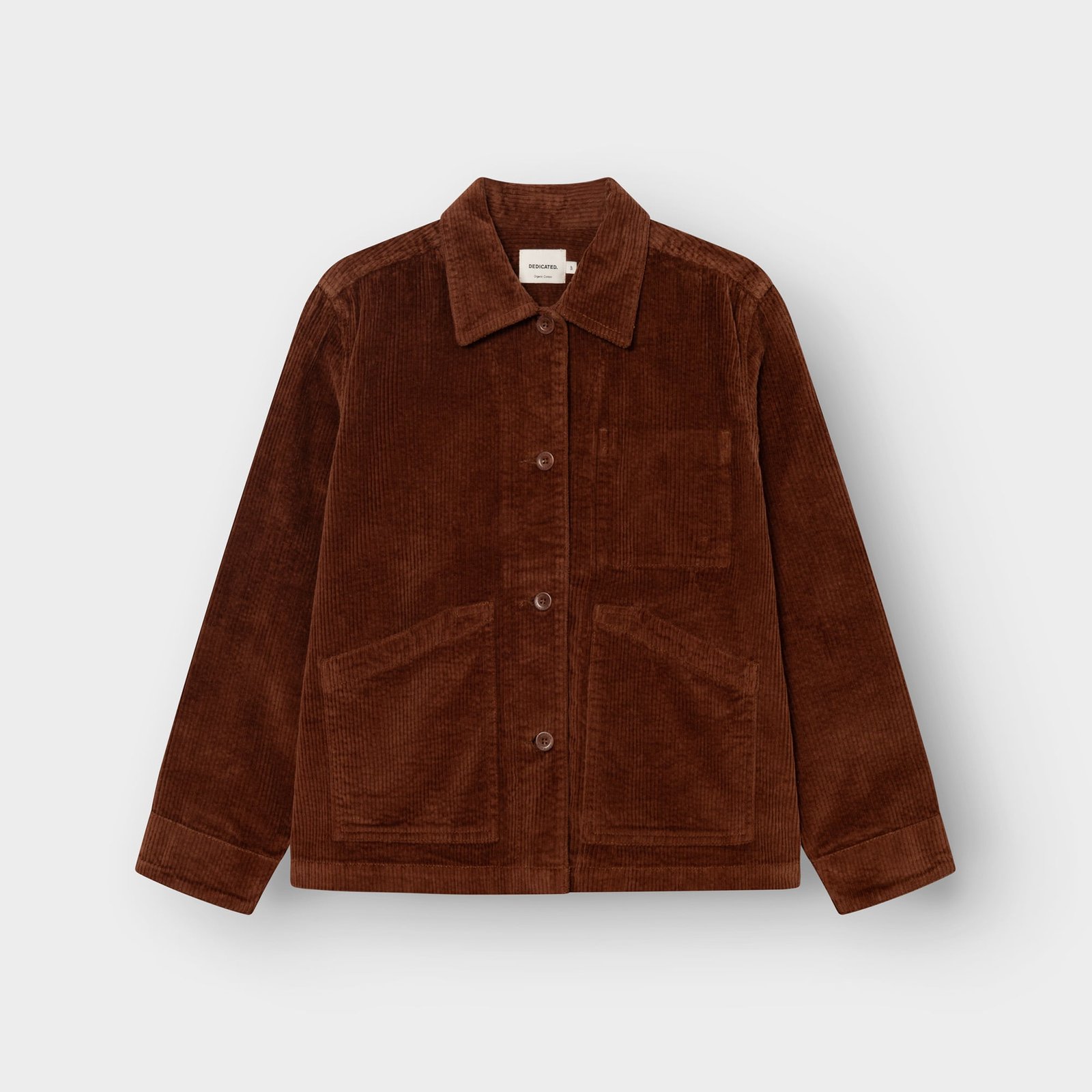 A flat-lay image of the Dedicated Stiby Corduroy Jacket in a rich Cappuccino Brown, showing its front pockets and buttons.