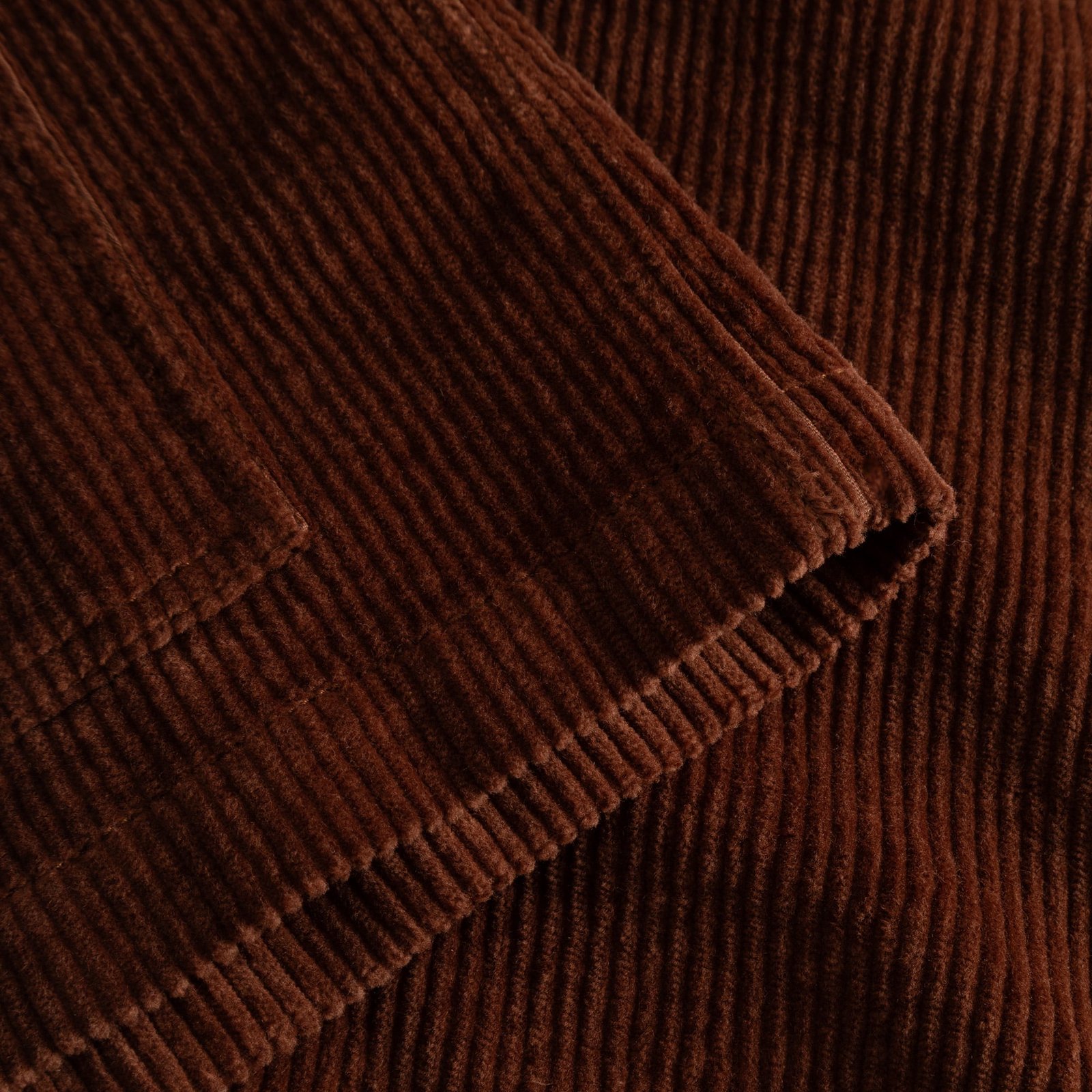 Close-up detail shot of the soft, ribbed corduroy fabric of the Stiby Jacket in a warm cappuccino brown.