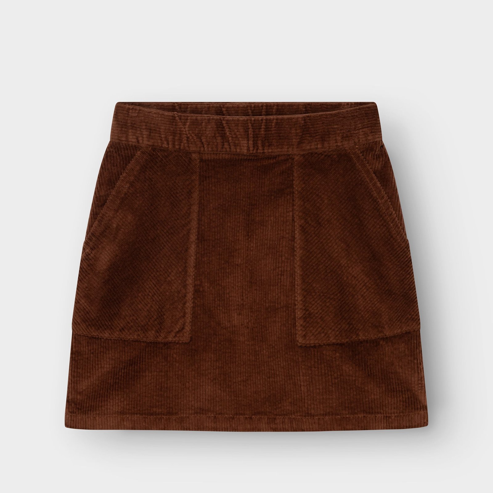 Front view of the Majorna A-line skirt in cappuccino brown corduroy, featuring two large front patch pockets.