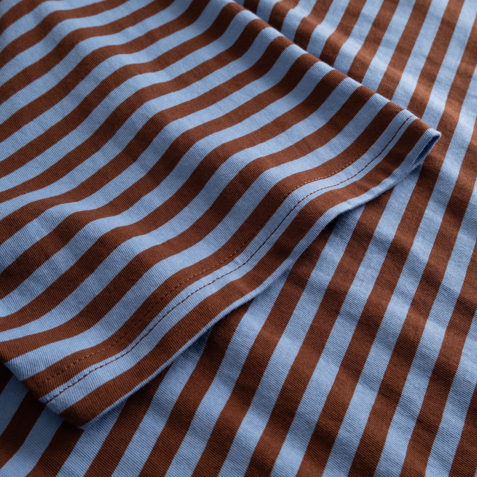 A detailed close-up of the sleeve on the T-shirt Stockholm Stripes in Cappuccino Brown and Cornflower Blue organic cotton.
