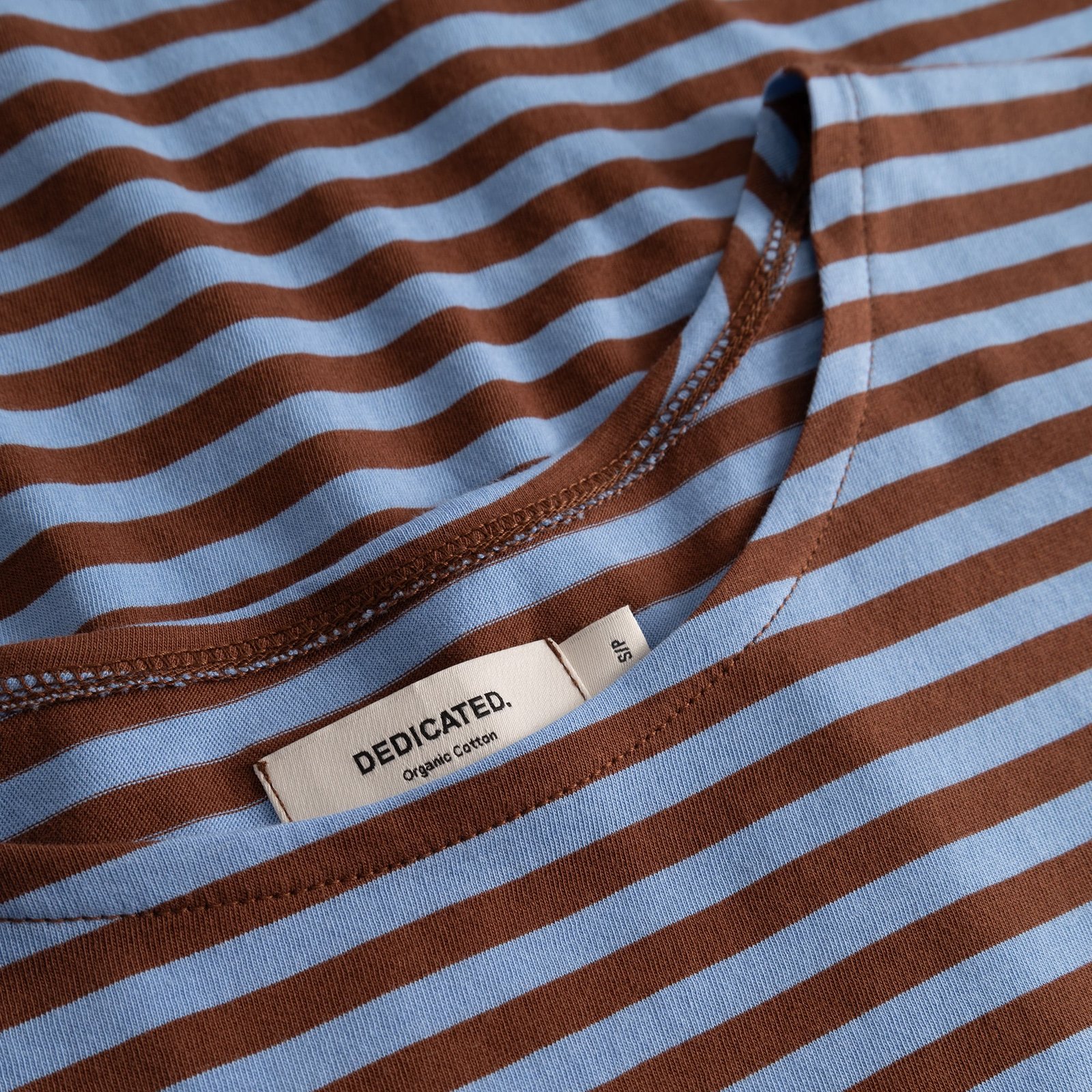 Detailed close-up of the Top Humledal in cappuccino brown and cornflower blue stripes, showing the neckline and brand label.