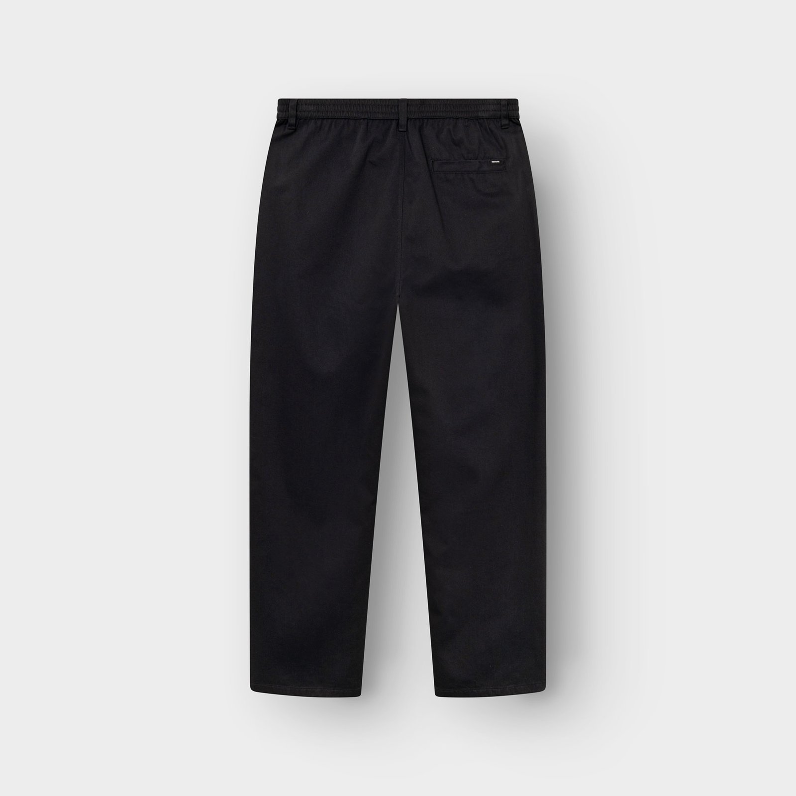 A flat lay of the Chino Pants Hudiksvall in black, showing the back view with its elastic waistband and single welt pocket.