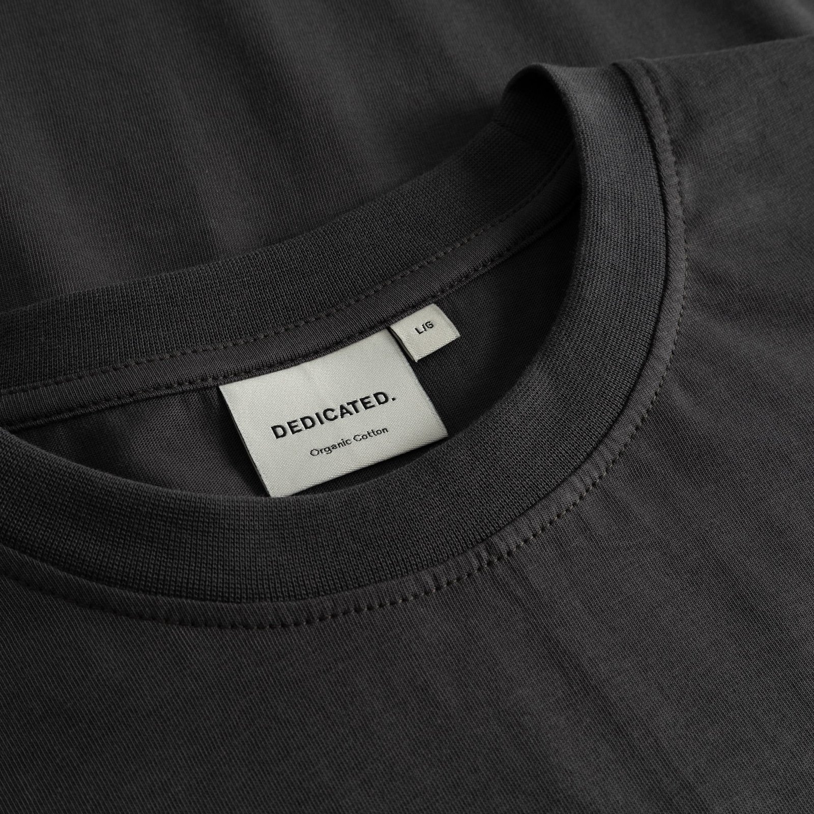 A close-up of the ribbed collar and woven brand label inside the charcoal T-shirt Stockholm Im Fashion.