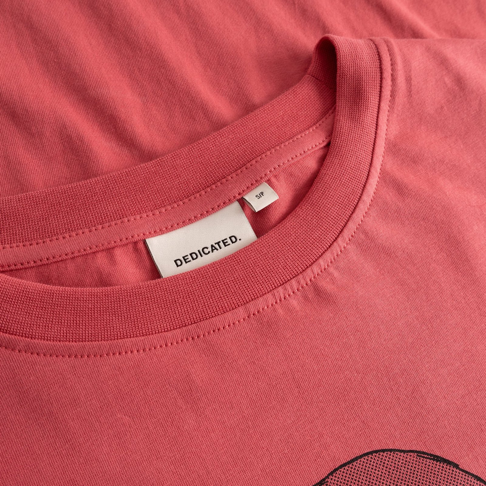 A close-up shot of the ribbed crew neck and brand label on the T-shirt Vadstena in Holly Red.