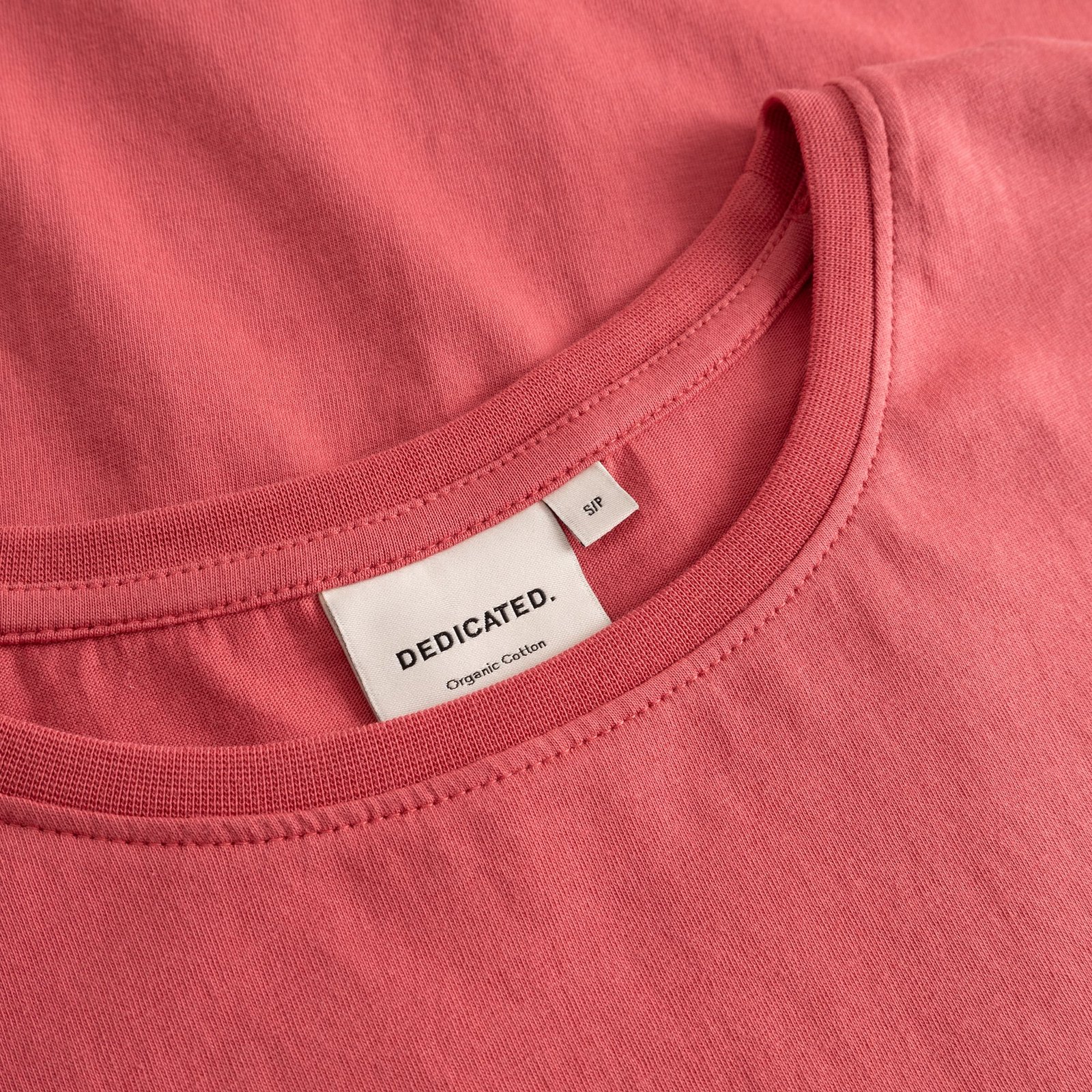 Detailed close-up shot of the T-shirt Visby Base in Holly Red, showing the ribbed neckline and Dedicated brand label.
