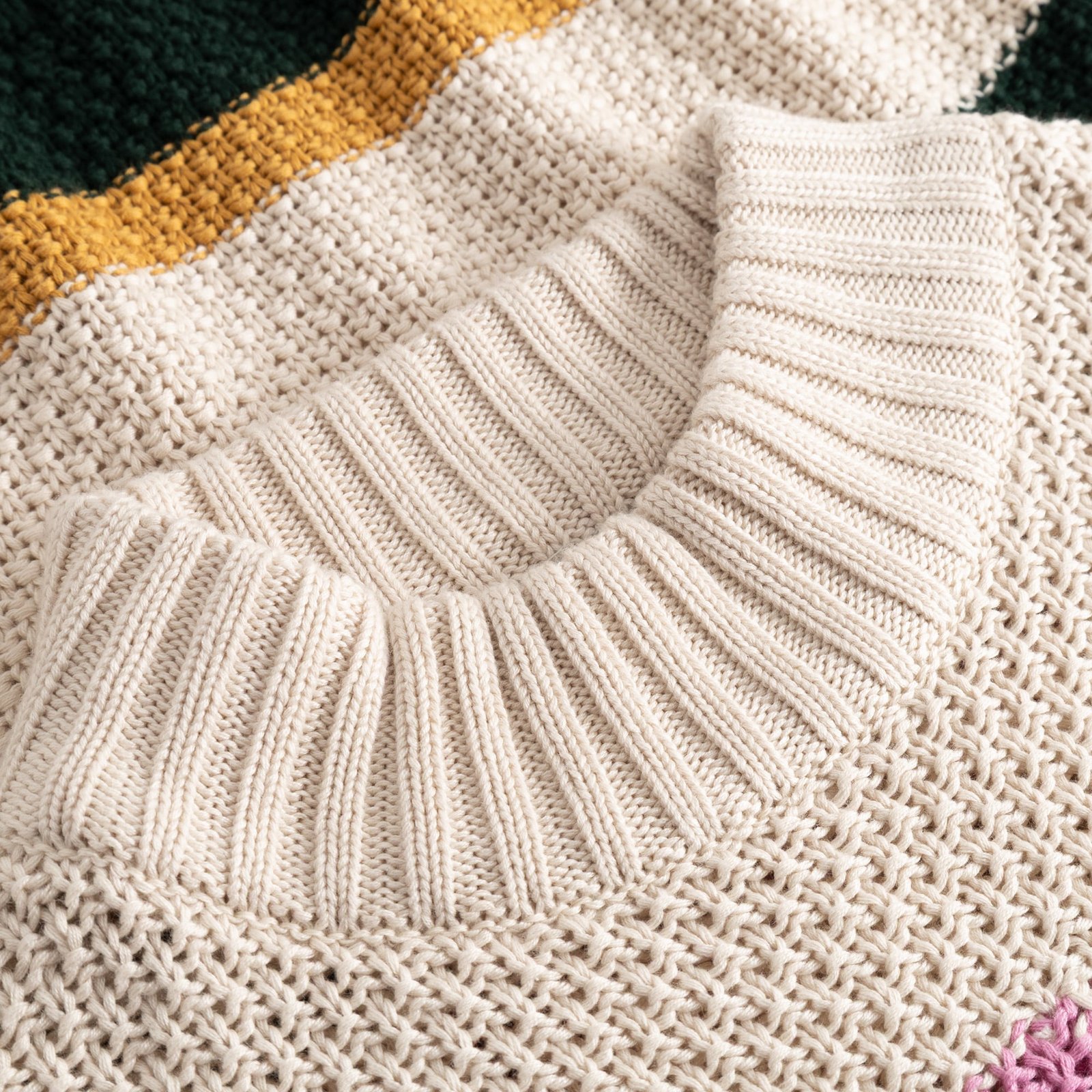 Close-up of the cozy ribbed high neck and chunky knit of the multi-colored Sweater Gotland Offset Stripe.