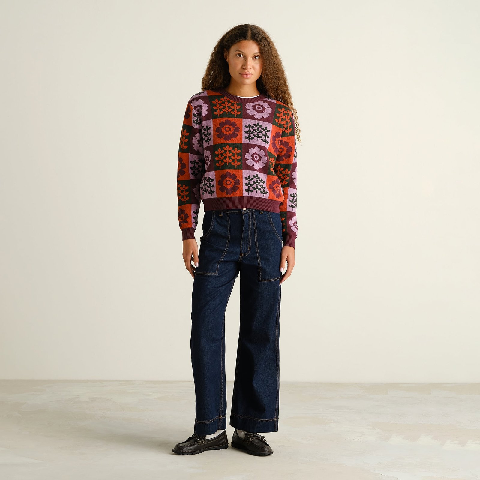 Full-length photo of a model wearing the jacquard-knit Sweater Arendal Nature Check, styled with wide-leg dark denim.