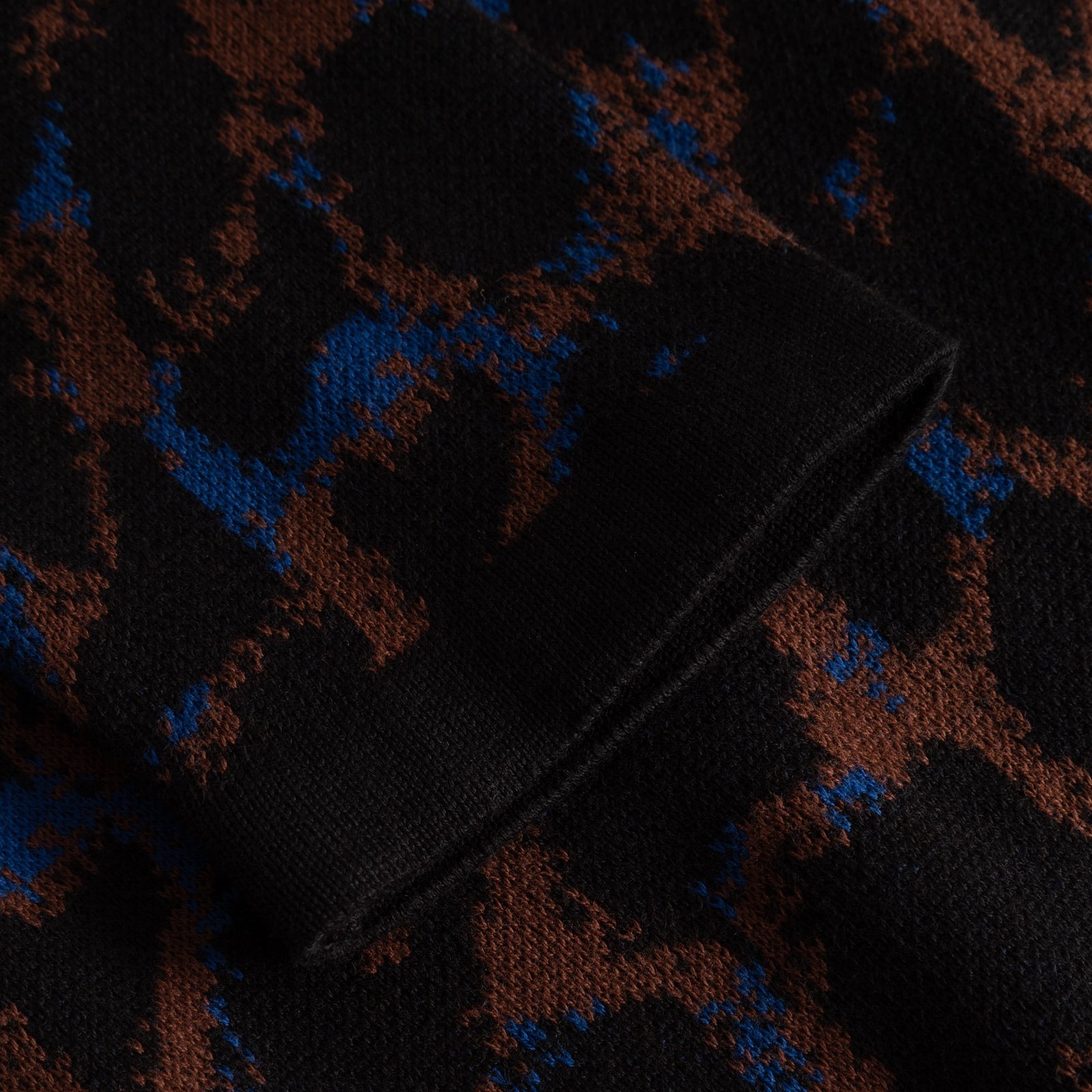 Detailaufnahme des gerippten Ärmelbündchens vom Kleid Lo Leopard aus weichem Strick mit mehrfarbigem Muster.