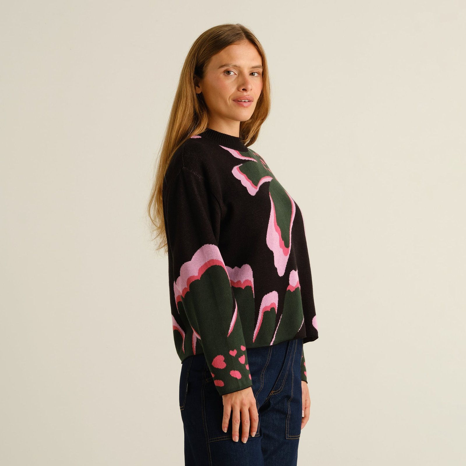 Close-up side view of a woman wearing the Dedicated Sweater Limhamn, featuring the colorful 'Big Bloom' floral pattern.