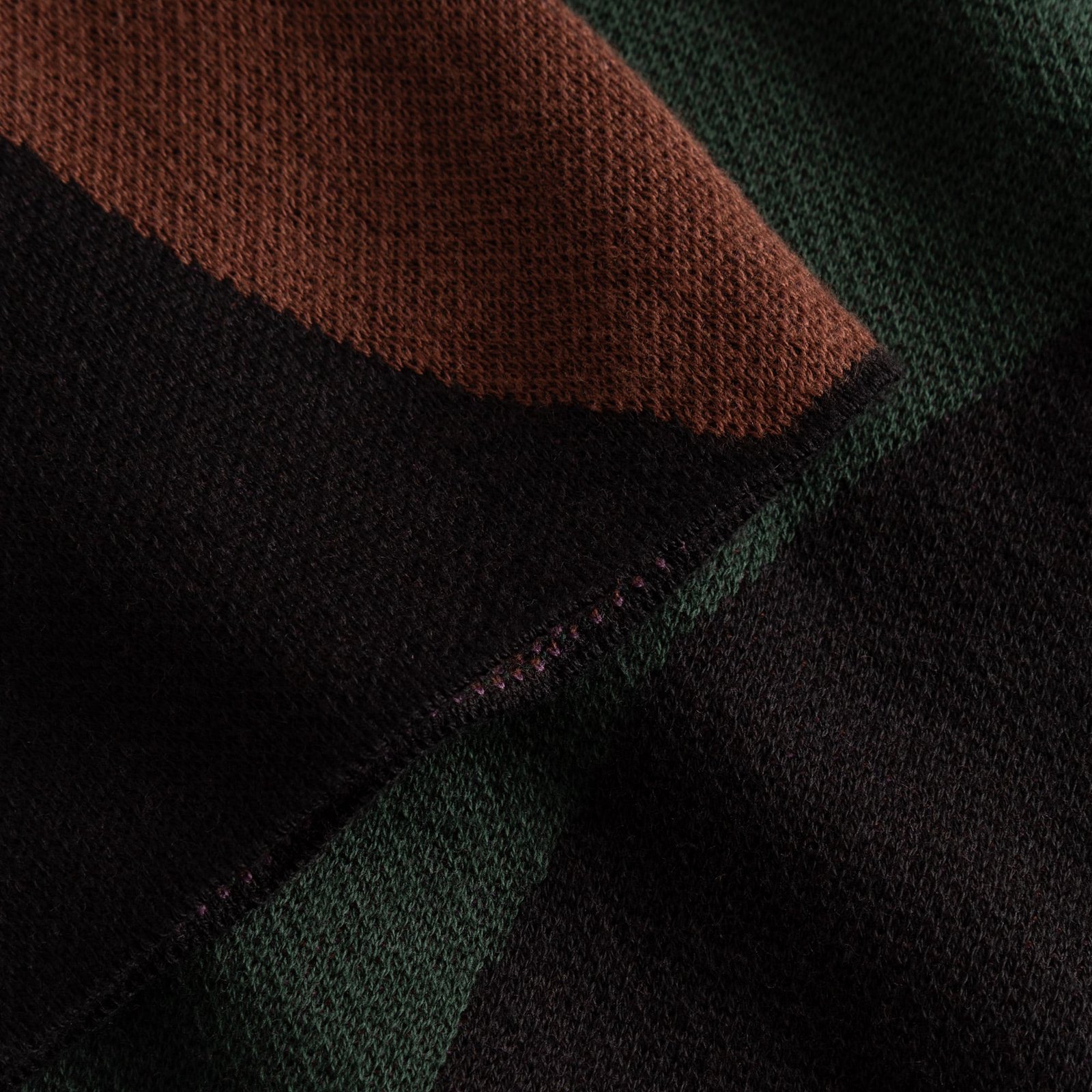 A close-up of the Dress Nikkala's soft jacquard knit, showing the wavy stripes in brown, deep green, and black.