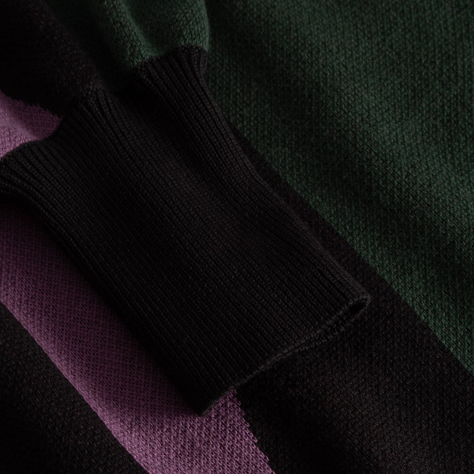 A detailed close-up of the multi-colored Dress Nikkala, focusing on the fine knit texture and the soft, black ribbed cuff.