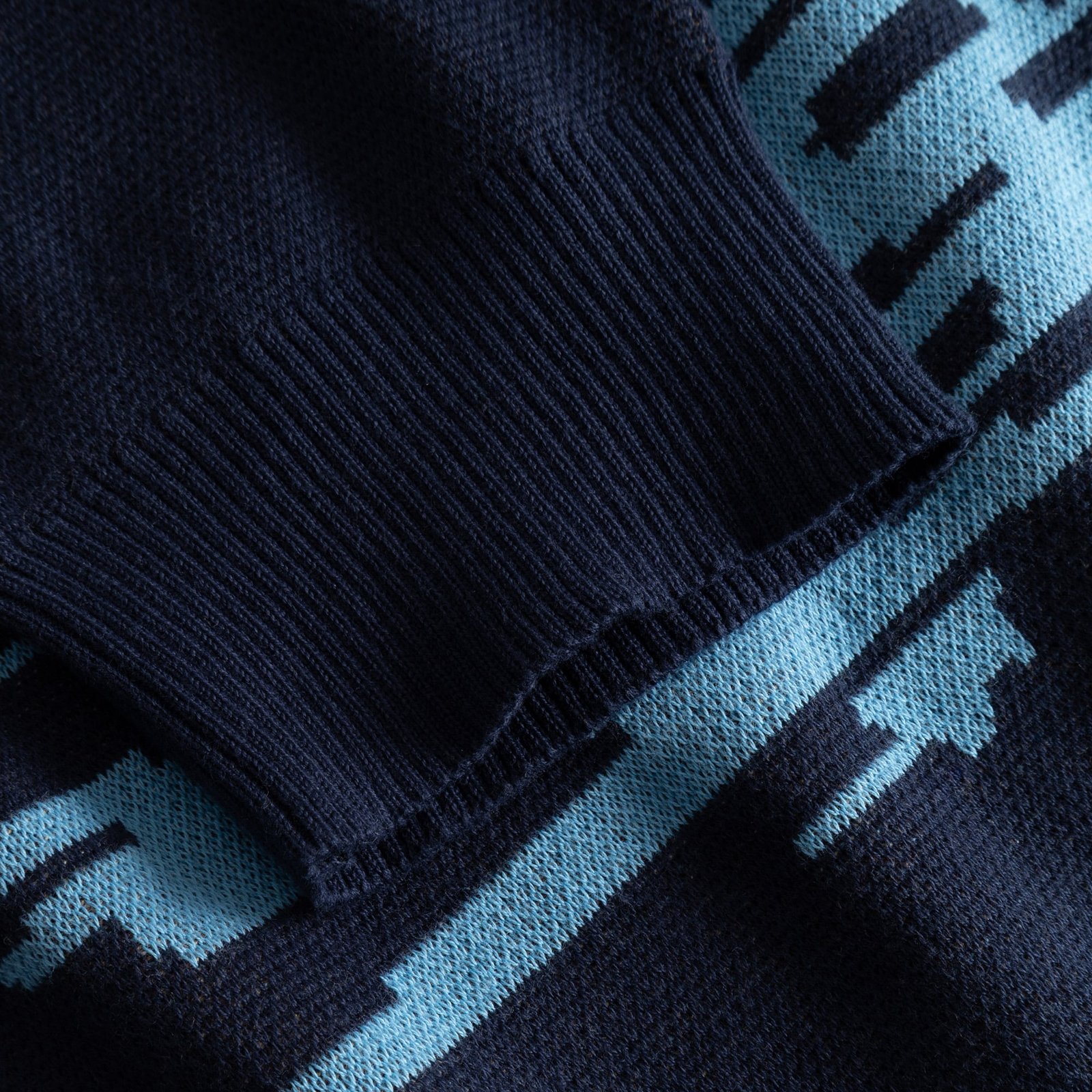 A close-up of the Sweater Mora Man and Sea, highlighting the detailed jacquard knit and soft ribbed cuff in organic cotton.