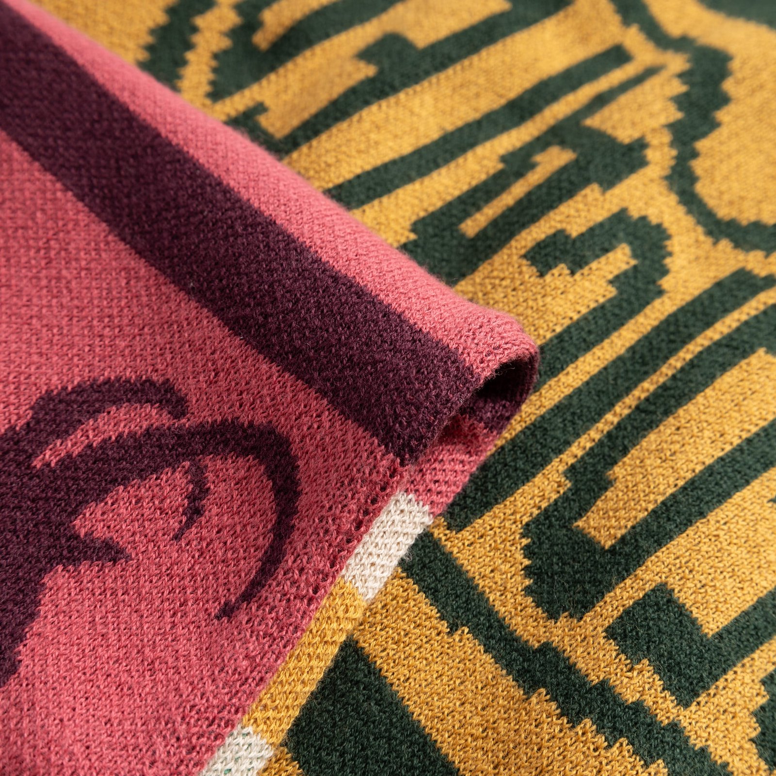 A detailed close-up of the Scarf Rossberga, showcasing the intricate jacquard knit and its vibrant retro ski block pattern.
