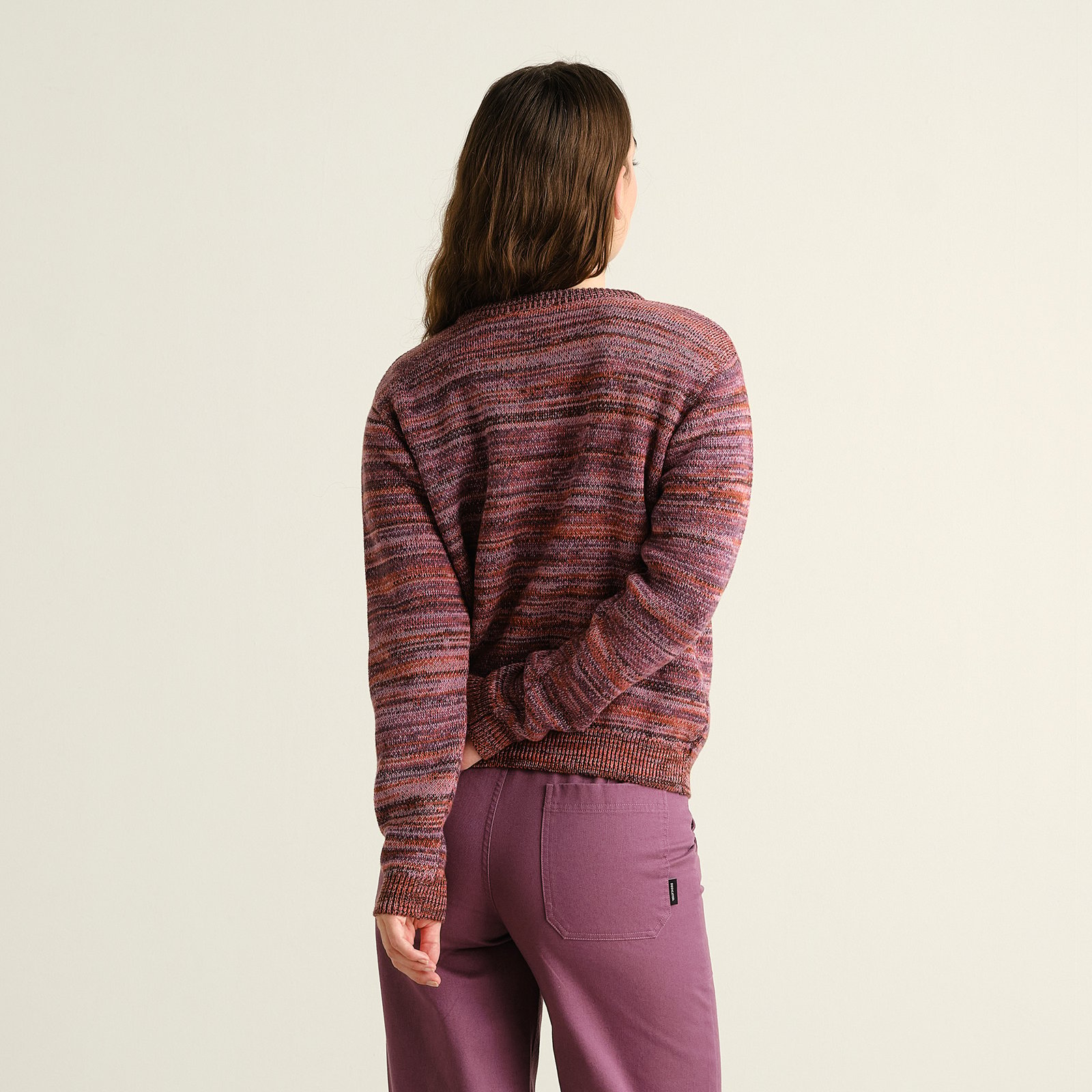 Back view of a model wearing the Arendal TY Swan sweater, a jacquard knit in beautiful multi-colored tones.
