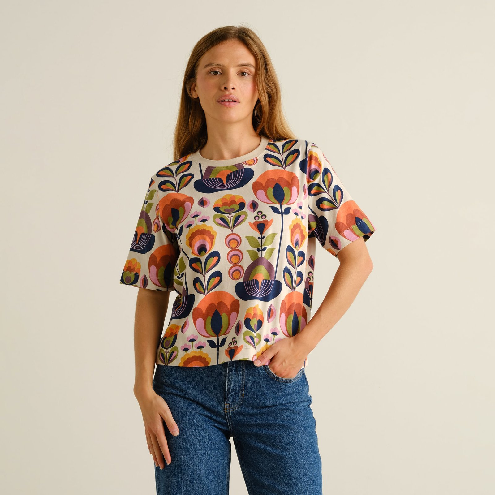 A woman models the relaxed-fit Vadstena T-shirt with its colorful Autumn Harvest print, styled with blue jeans.