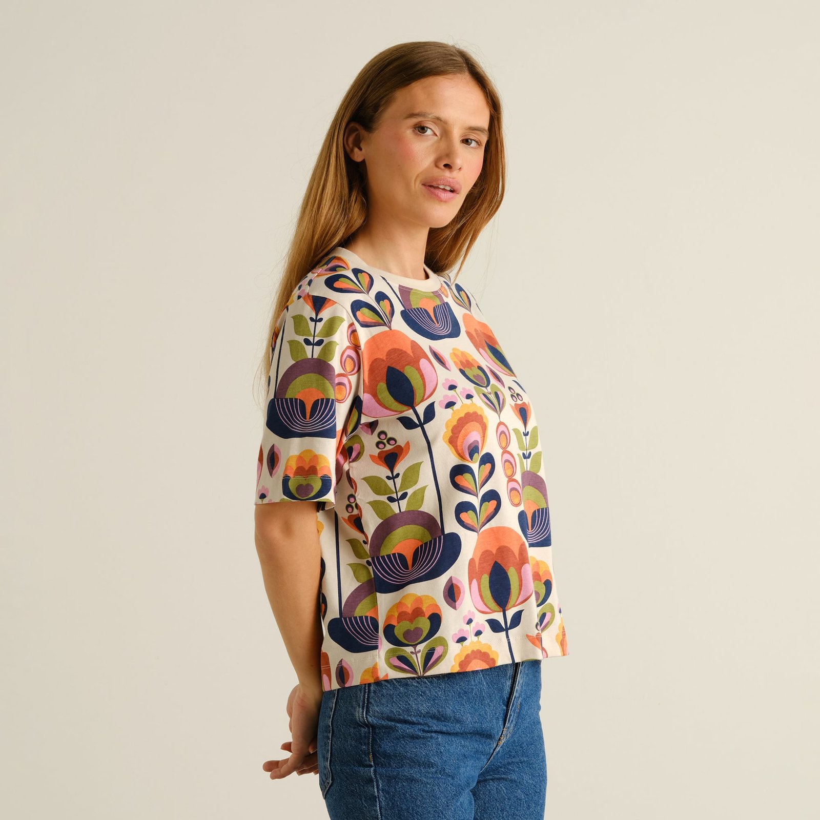 Model looking over her shoulder, wearing the relaxed-fit Vadstena t-shirt with its bold, colorful Autumn Harvest print.