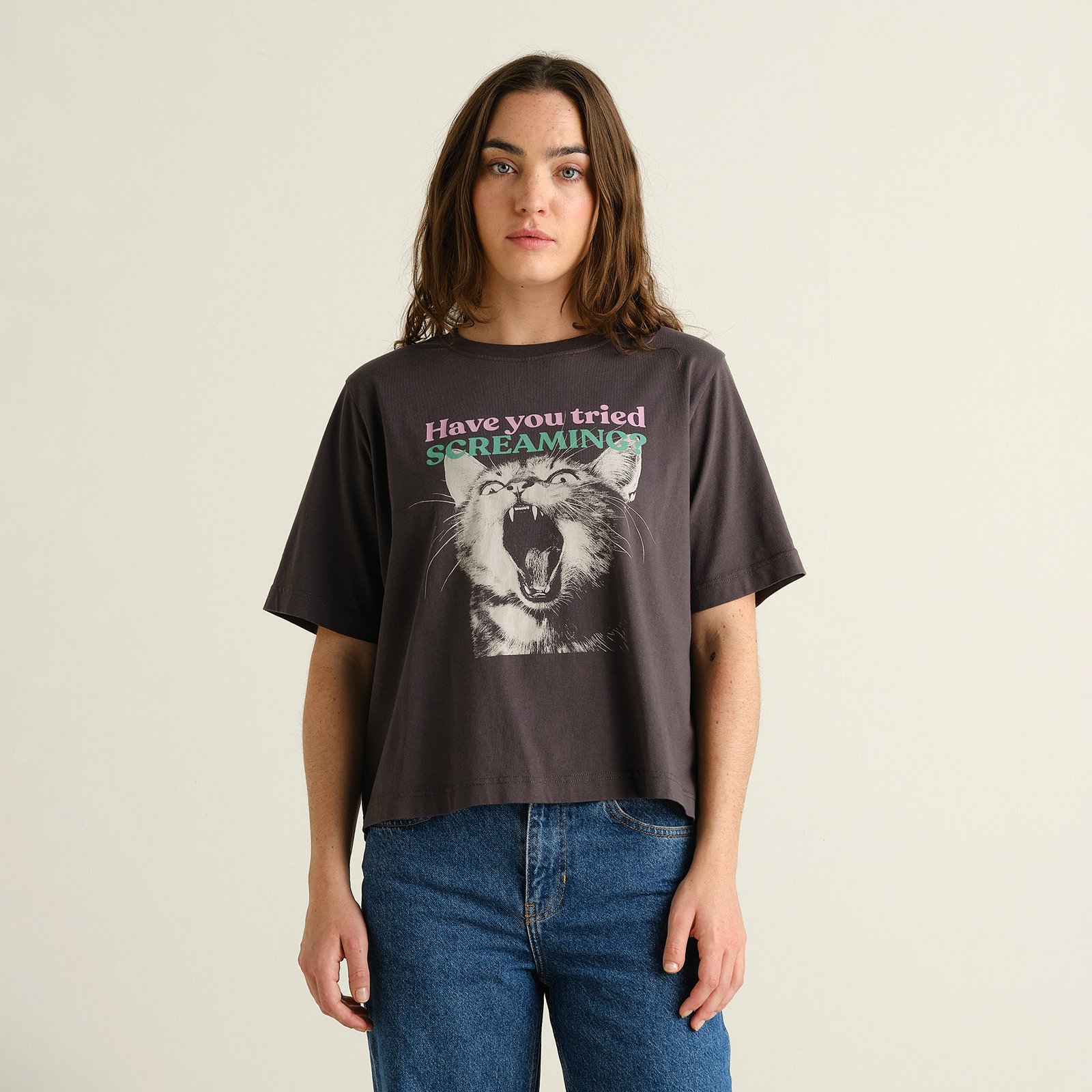 Model wearing the charcoal T-shirt Vadstena with a 'Screaming Cat' print, paired with blue jeans.