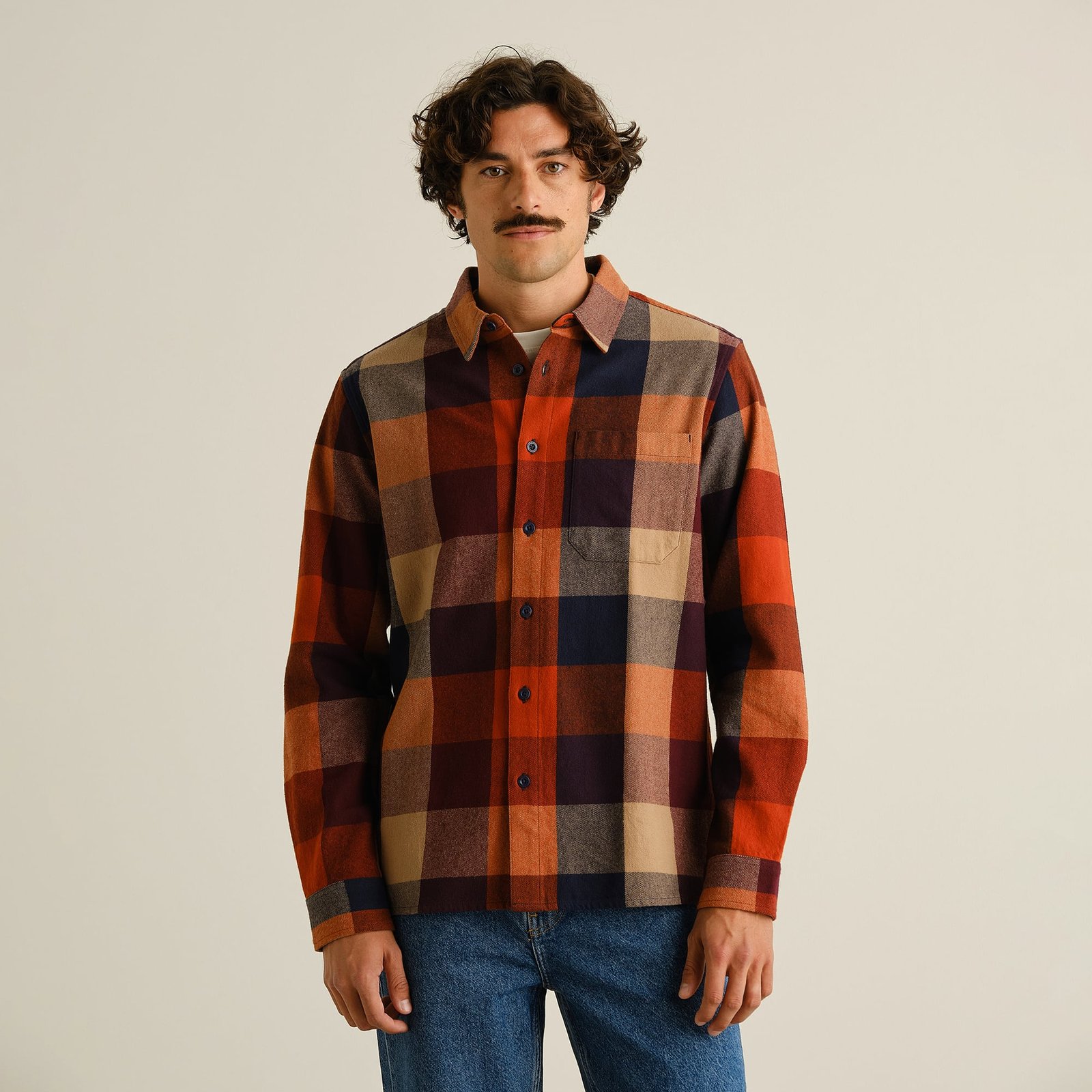 Front view of a model wearing the relaxed-fit Rute Flannel Check Shirt in a muted multi-color plaid.