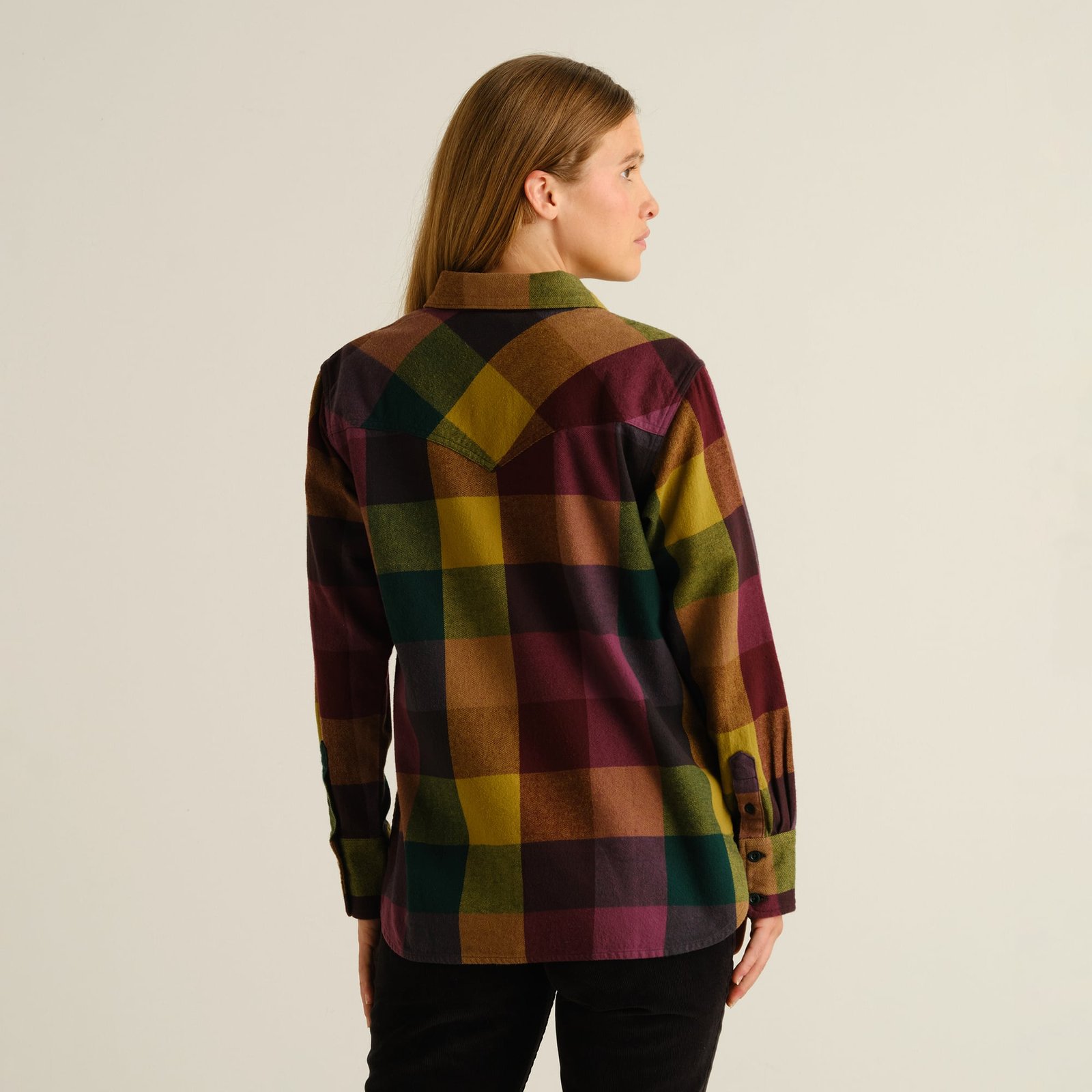 Woman wearing the Arboga Flannel Shirt in Bold Multi Color, seen from the back to show the western yoke and colorful plaid.