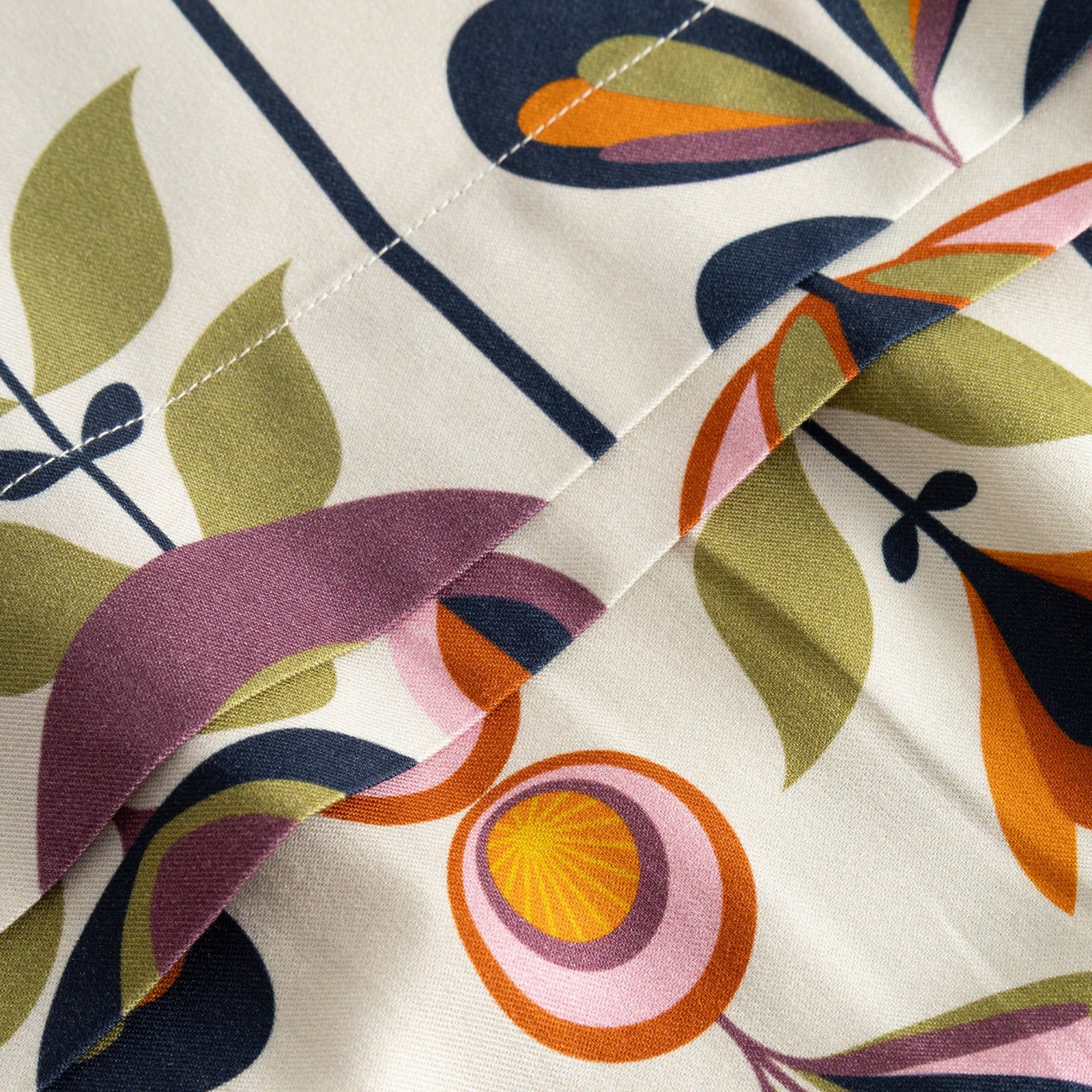 A close-up shot of the Skirt Viken, highlighting the colorful Autumn Harvest floral print and fine stitching detail.