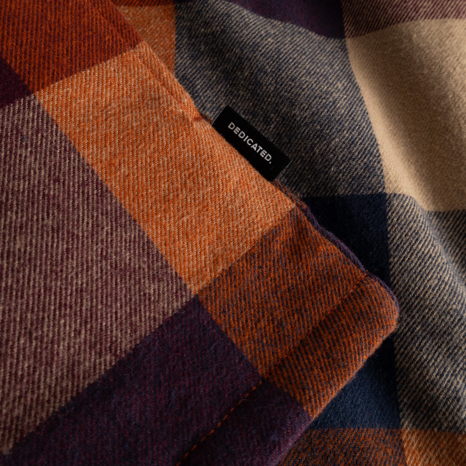 Close-up of the Jacket Torp in Muted Multi Color, showing the soft checked flannel fabric and the small Dedicated label.