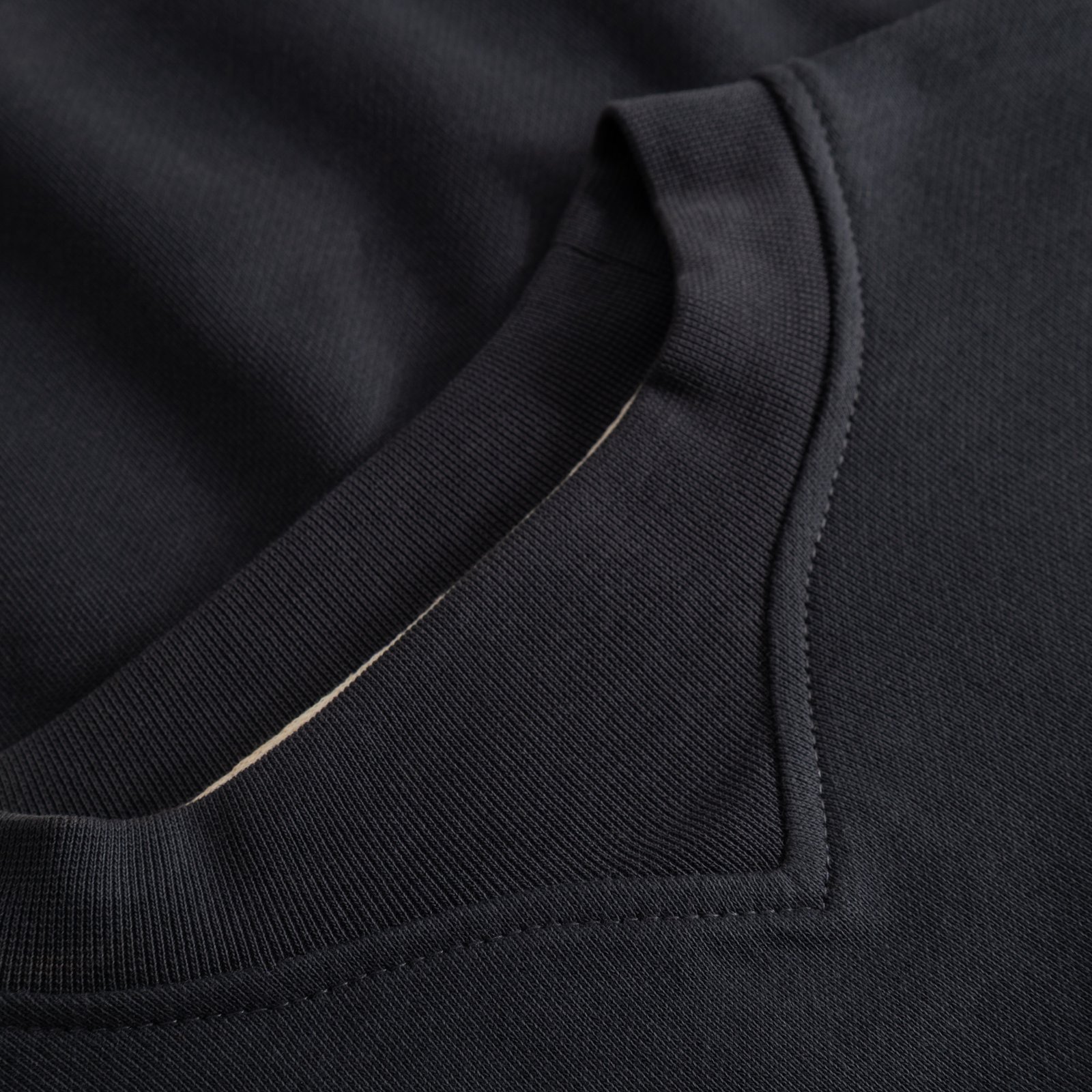 A detailed view of the Sweatshirt Gia in Phantom Black, focusing on the sophisticated V-shaped neck rib and soft texture.