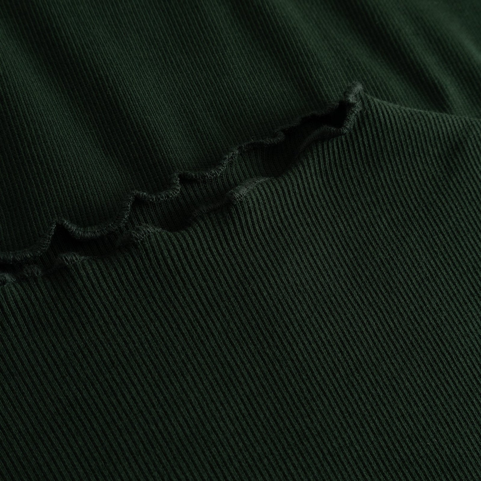 Close-up detail of the Rib Top Ryd in Dark Green, showing the fine ribbing and delicate lettuce-edge seam.