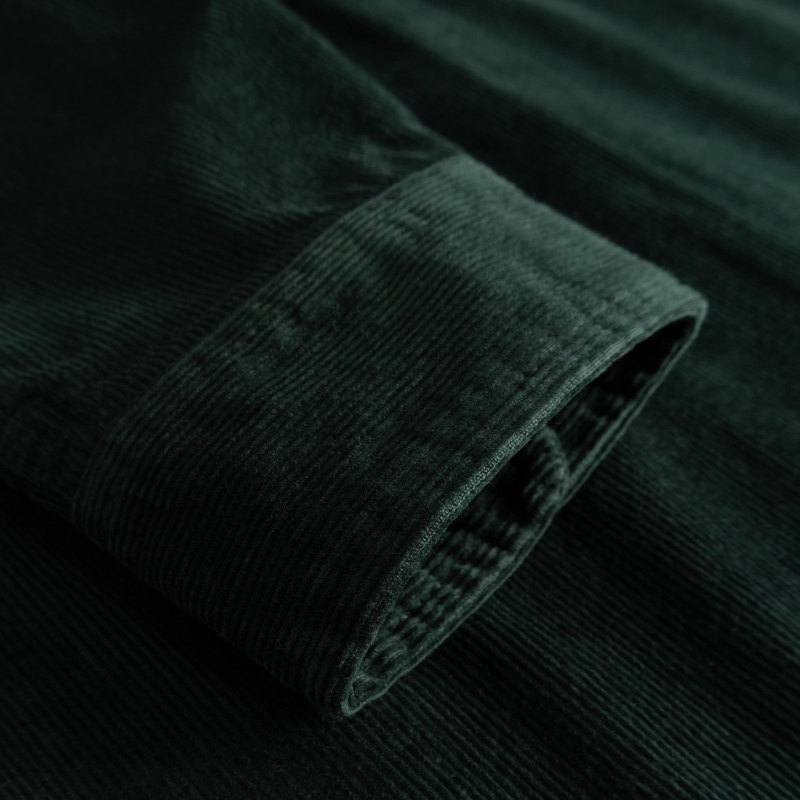 Close-up of the cuff on the Shirt Varberg, showcasing the rich, dark green corduroy fabric.
