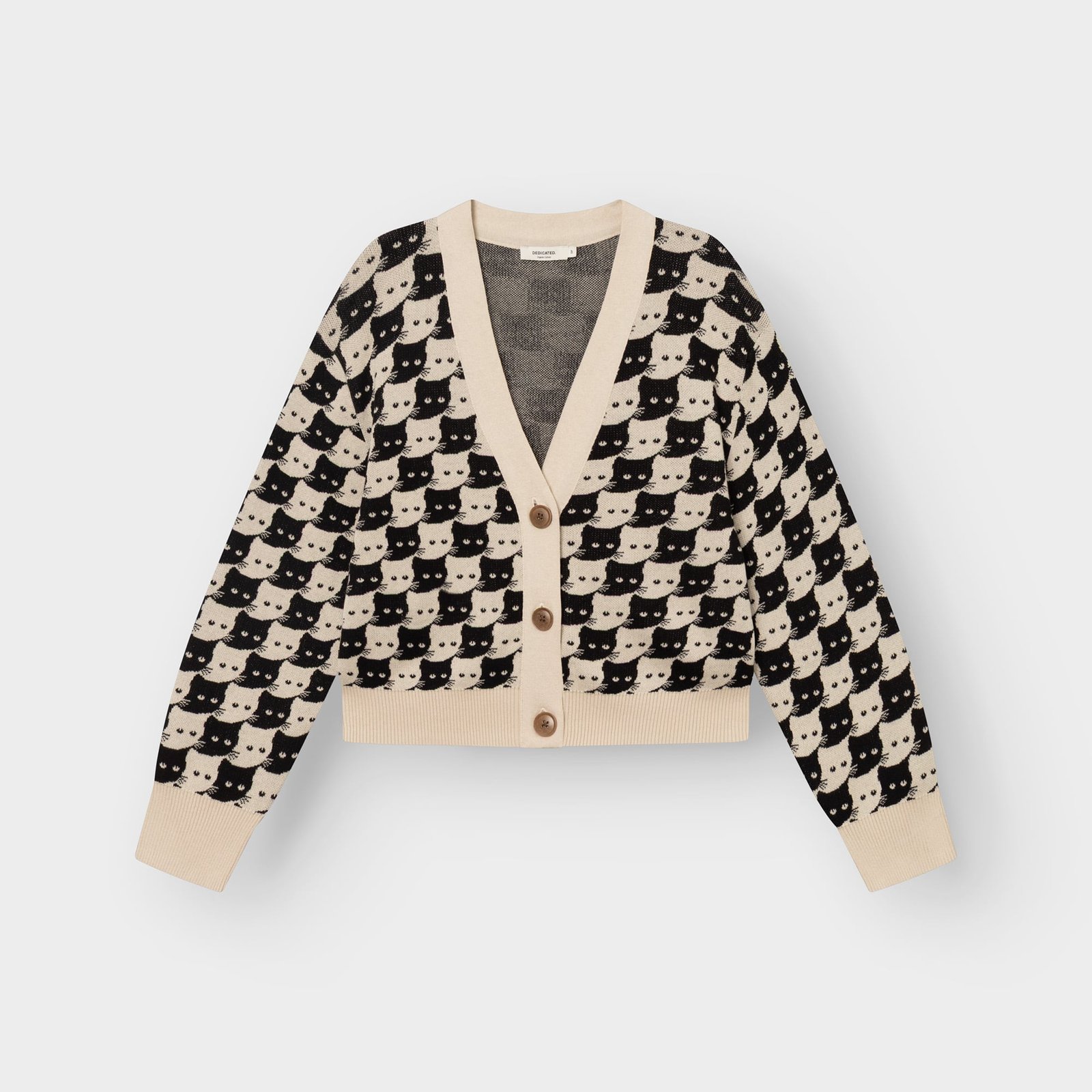 Studio shot of the Kanan cardigan in Oat White. This knitted V-neck is covered in a playful pattern of black and white cats.