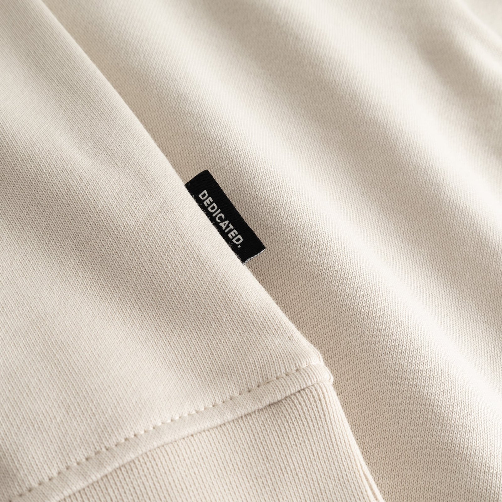 A close-up of the Sweatshirt Ystad in Oat White, highlighting the soft fabric and the signature Dedicated side label.