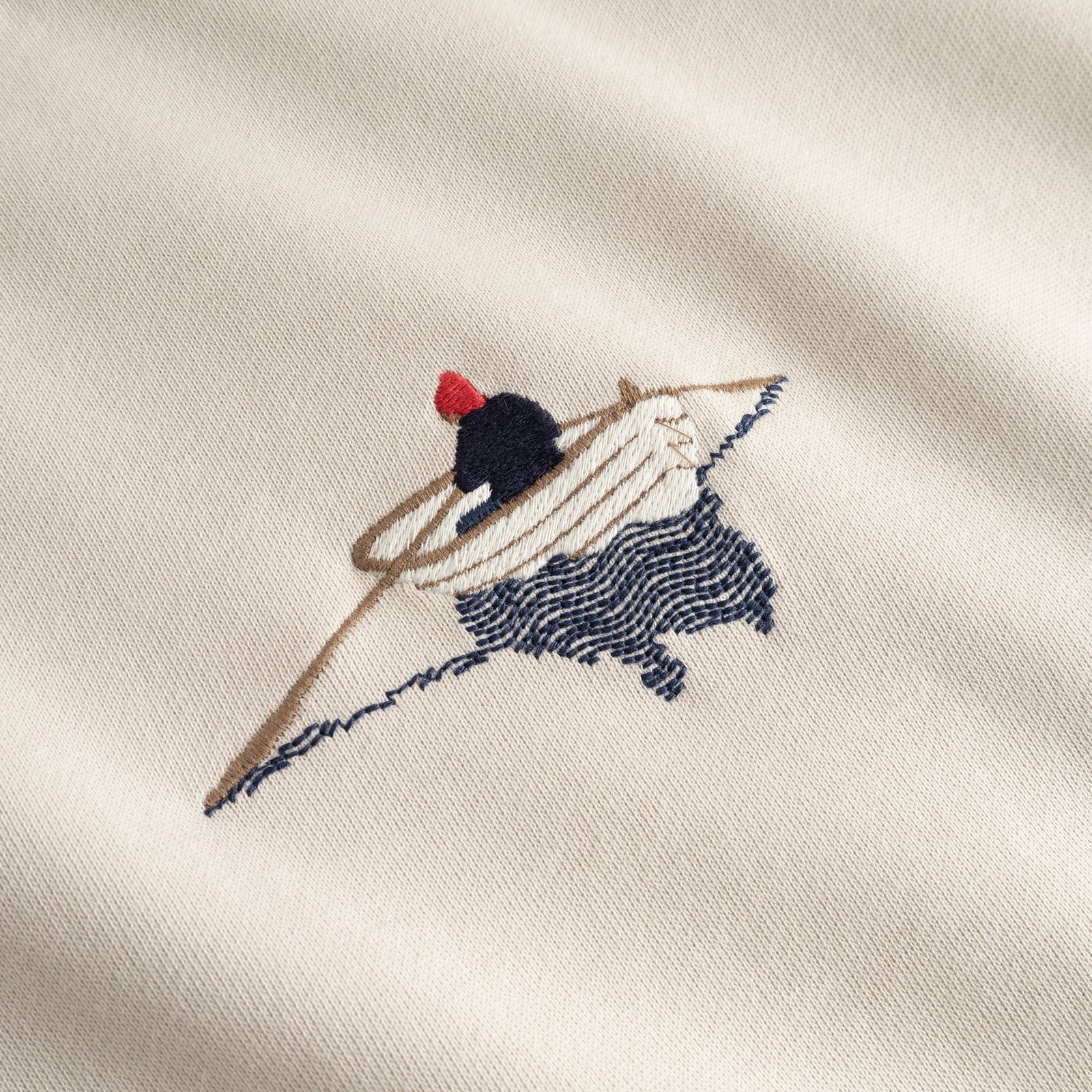A detailed close-up of the rowing boat embroidery on the chest of the oat white Sweatshirt Malmoe.