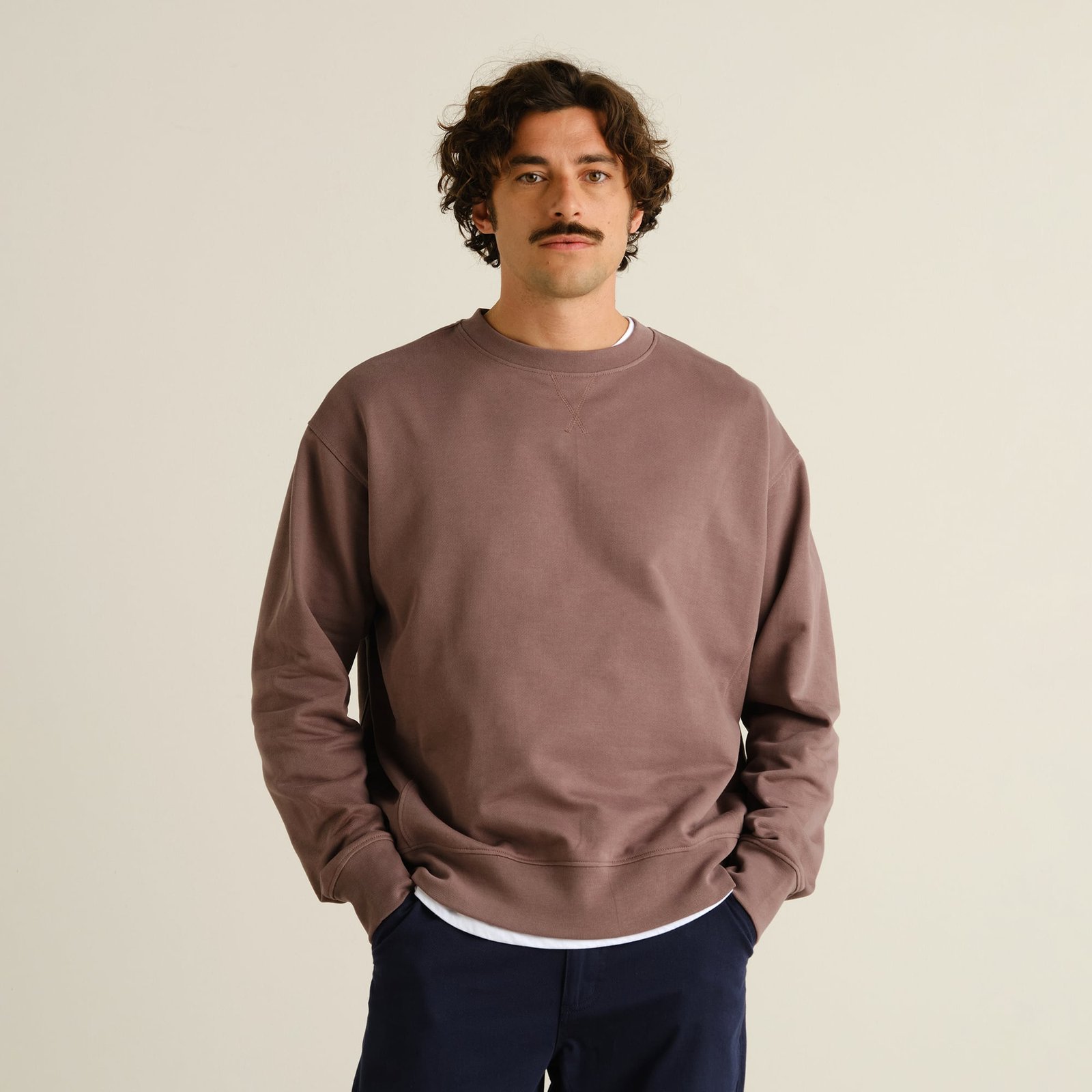 A model with curly hair wears the relaxed-fit Sweatshirt Bettna in Sparrow Brown with his hands in his pockets.