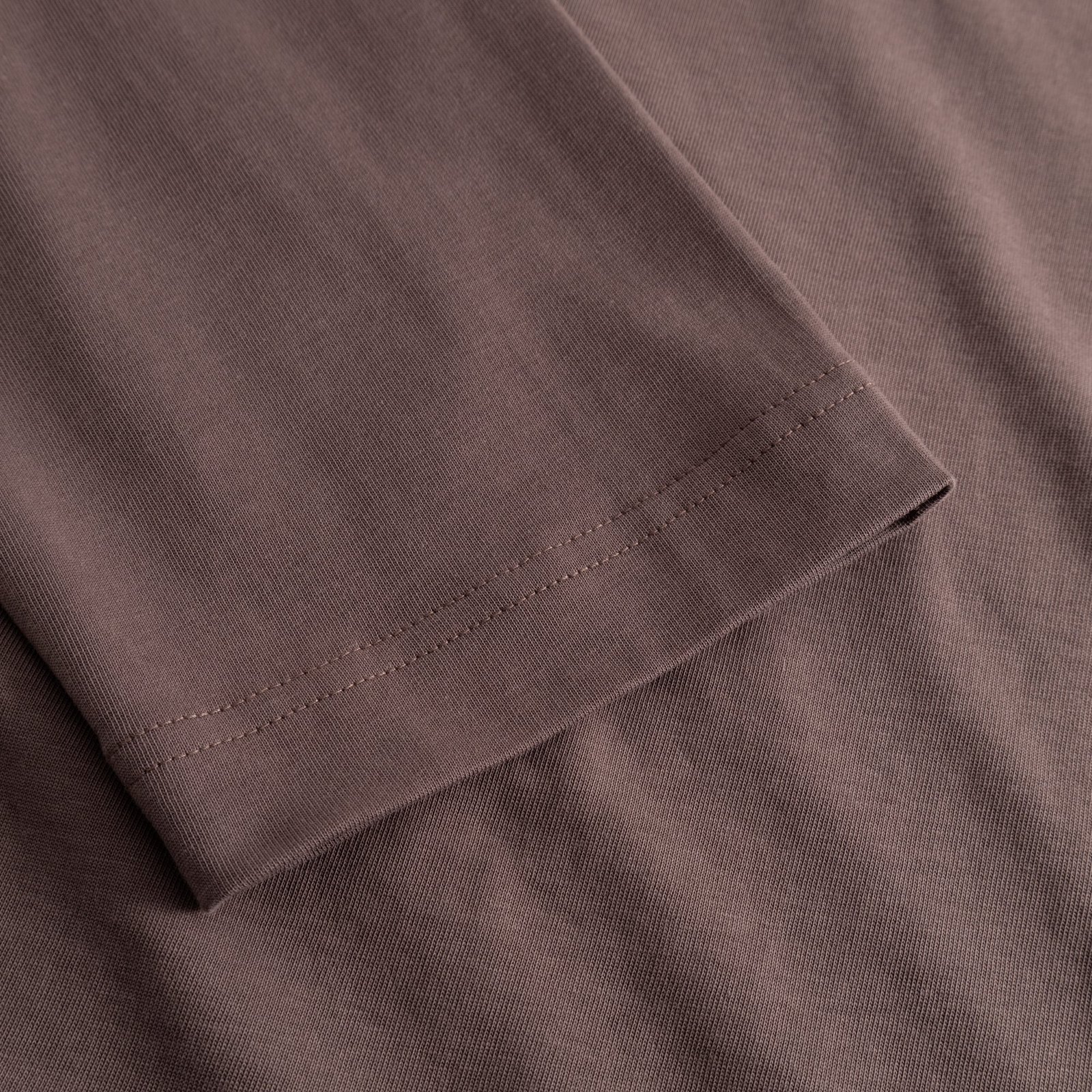 A detailed close-up of the sleeve on the Vreta long-sleeve T-shirt, showing the fine stitching and soft Sparrow Brown fabric.