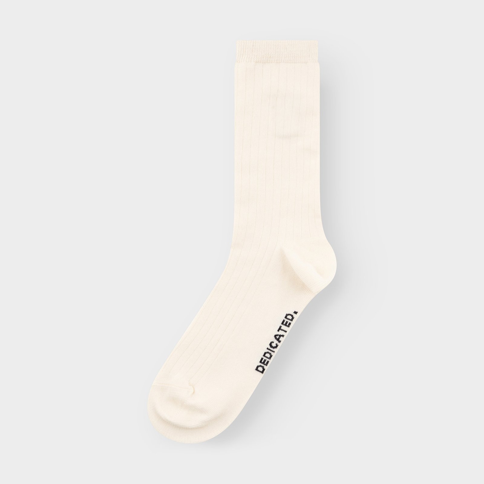 A single off-white ribbed sock, the Rib Socks Knivsta, from Dedicated, shown flat against a light grey background.