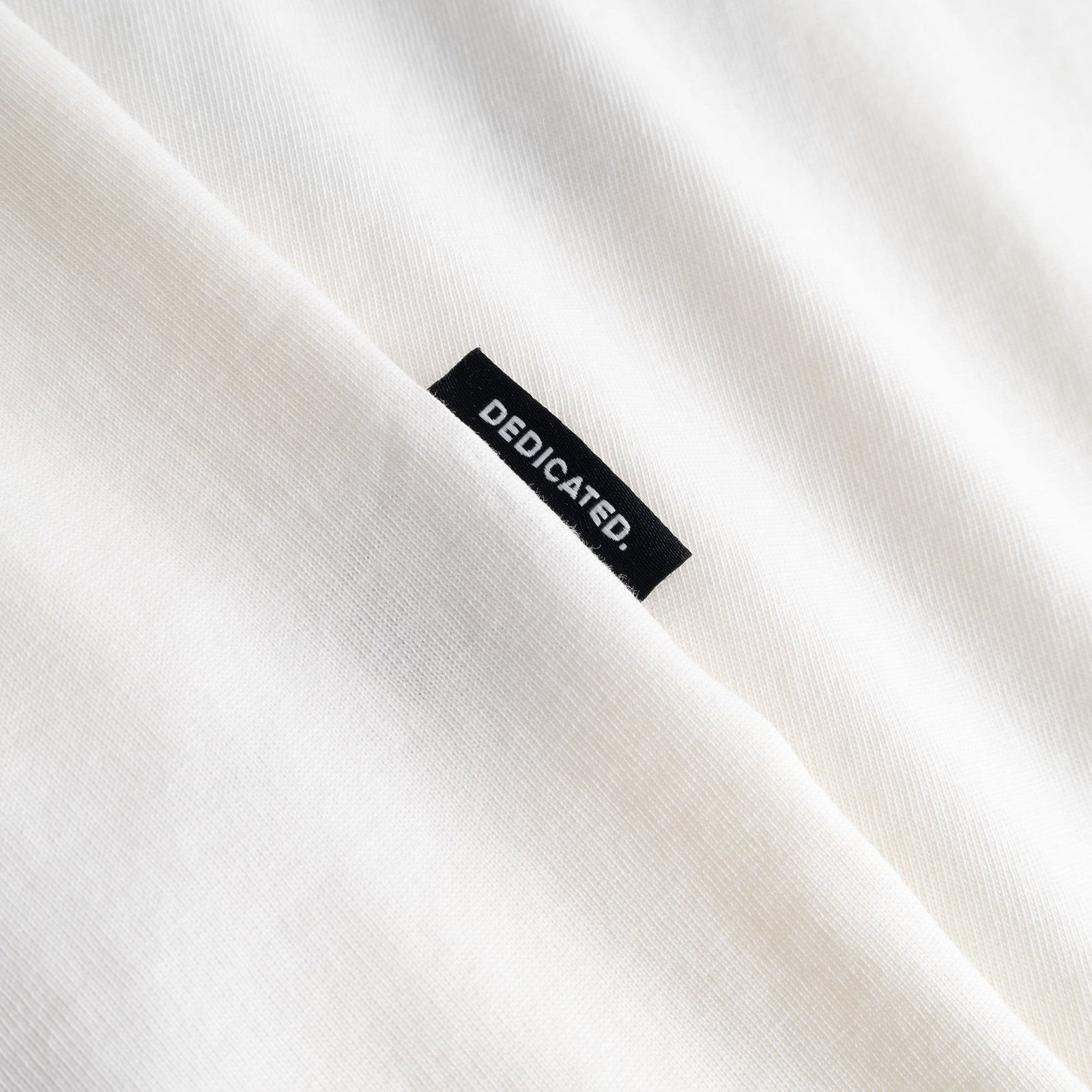 Our signature Dedicated label, seen here on the soft, off-white fabric of the T-shirt Stockholm Karaoke Killer.