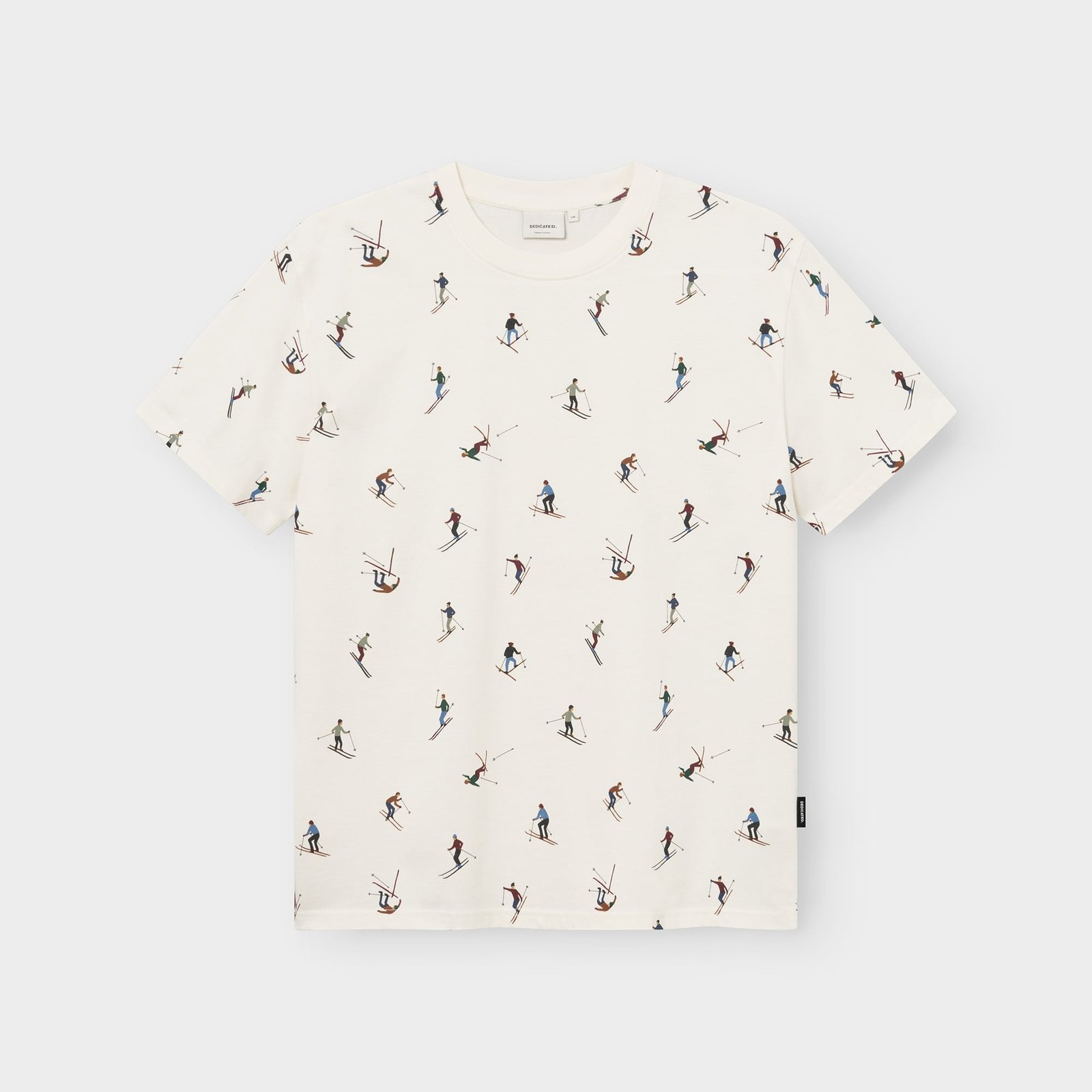 Flat lay of an off-white t-shirt with a fun all-over print featuring colorful illustrations of skiers.